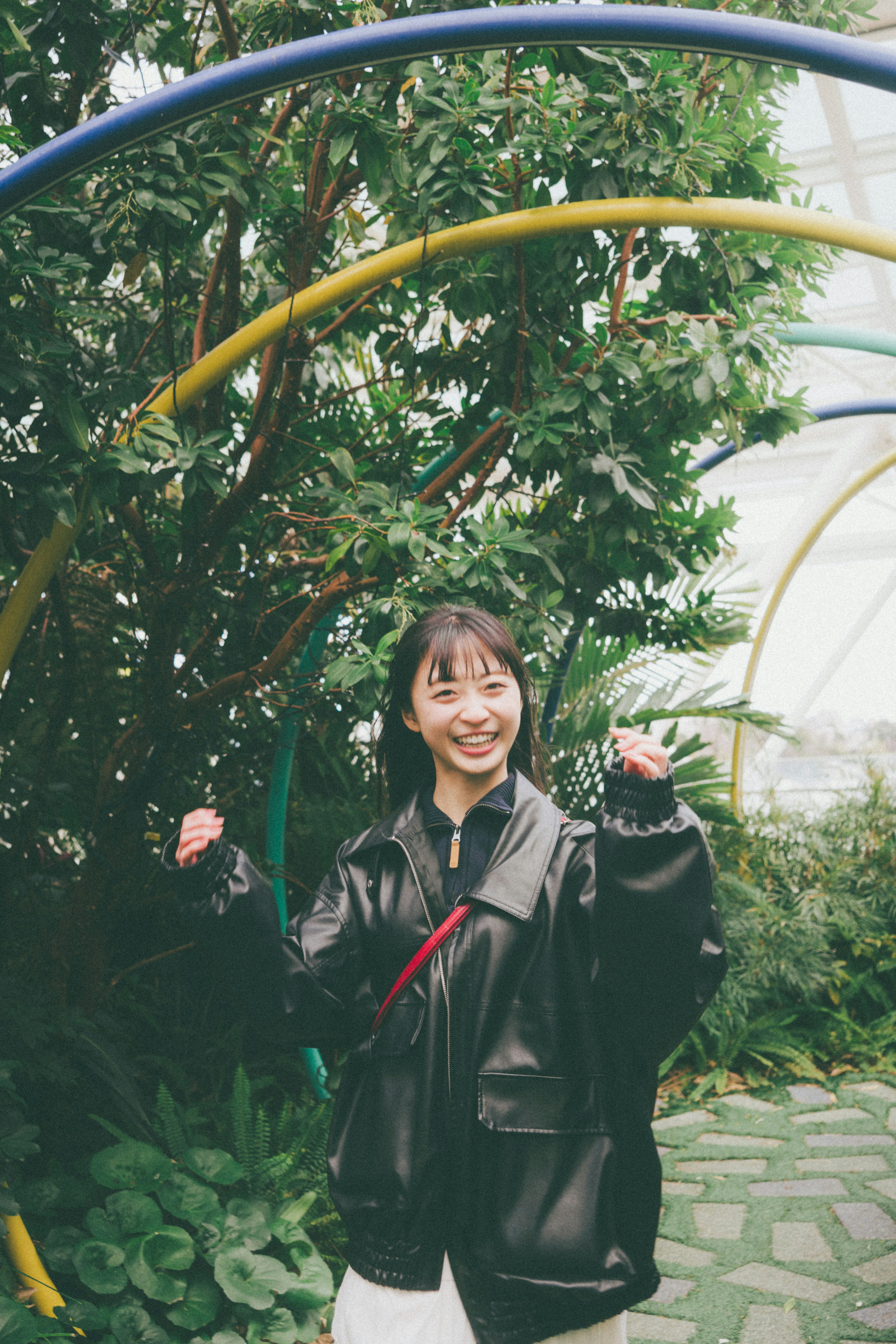 A smiling woman posing in a lush green background