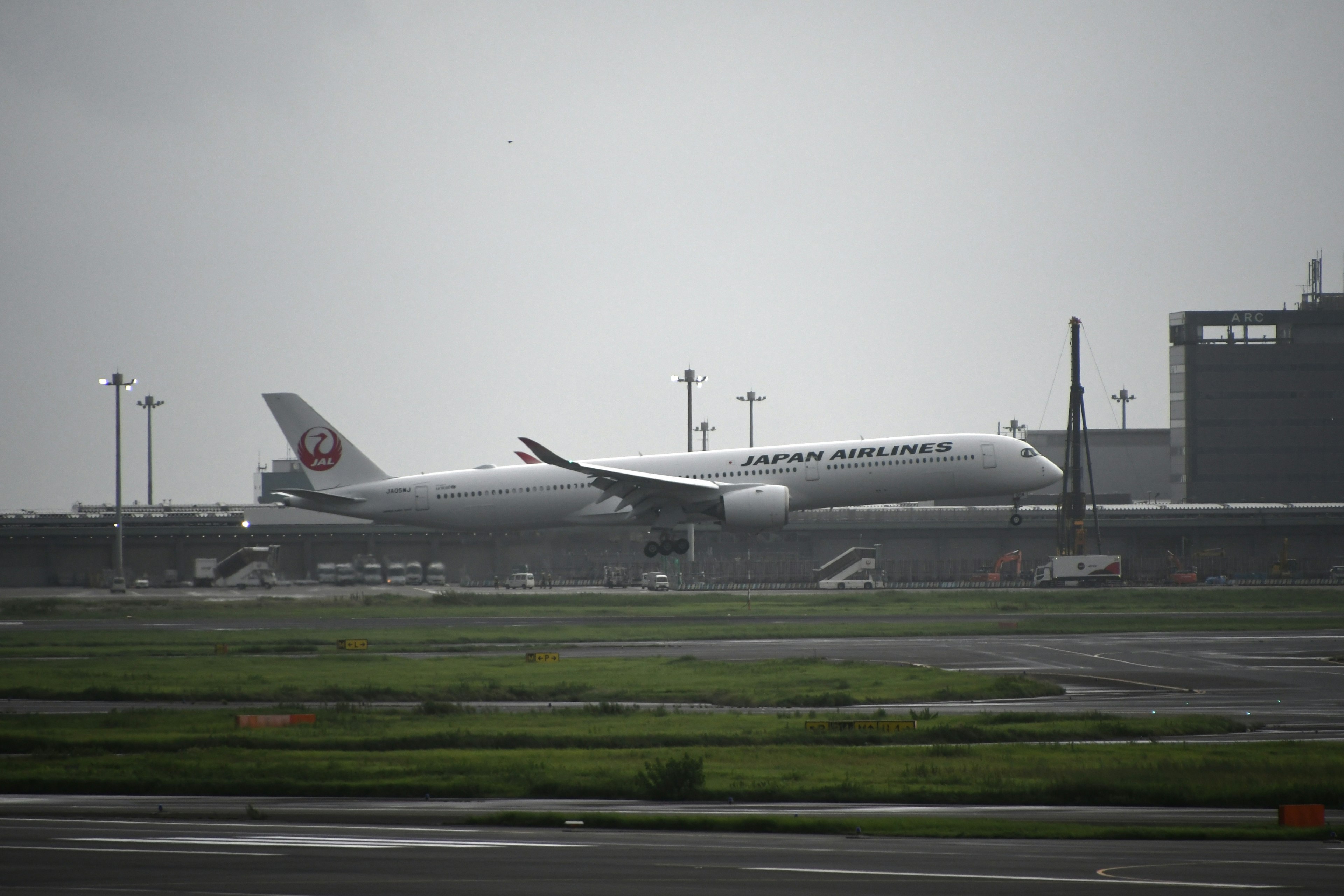 Japan Airlines airplane on the runway at an airport in foggy weather