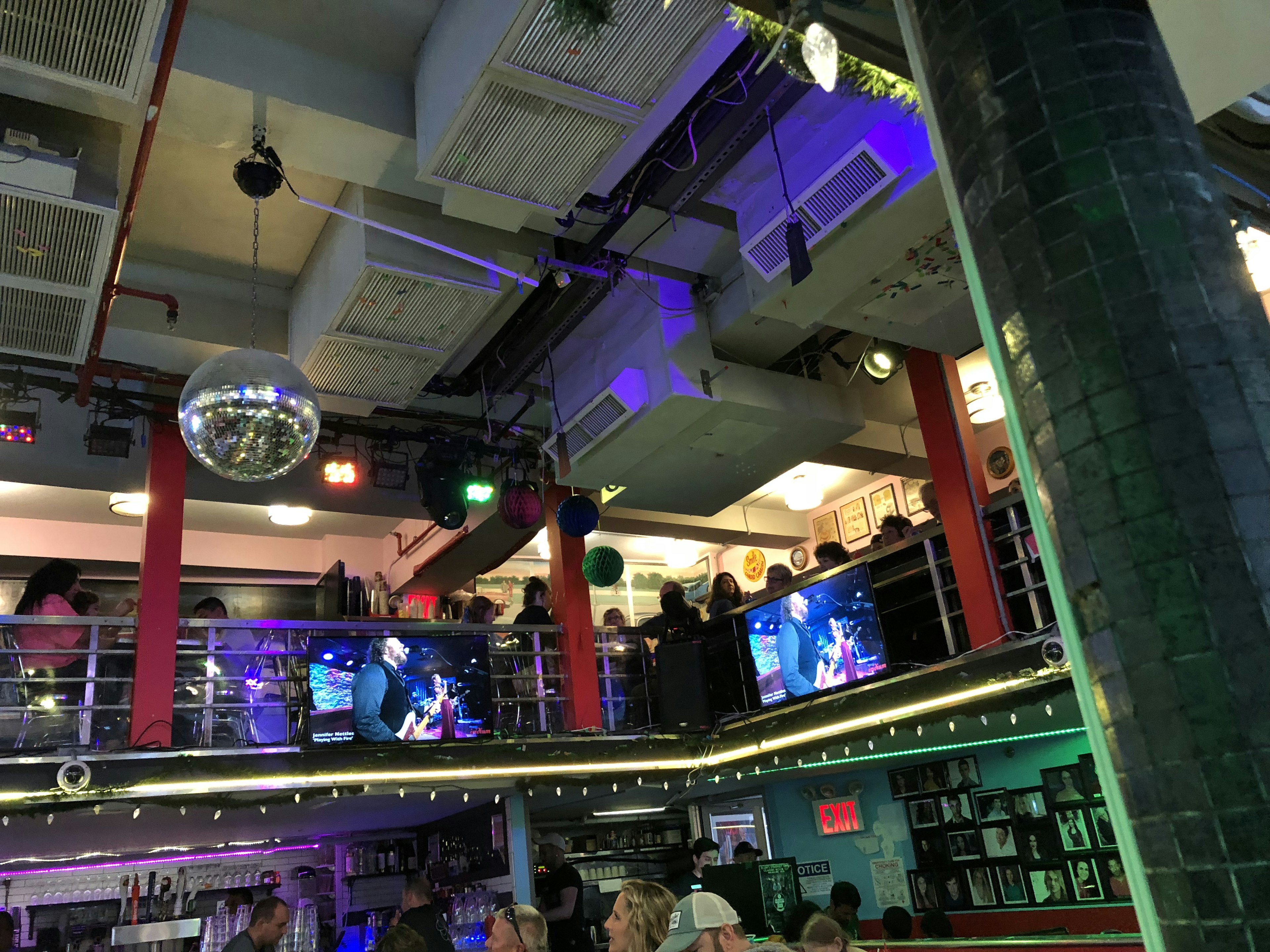 Vista interior de un bar con pista de baile Iluminación colorida y personas disfrutando