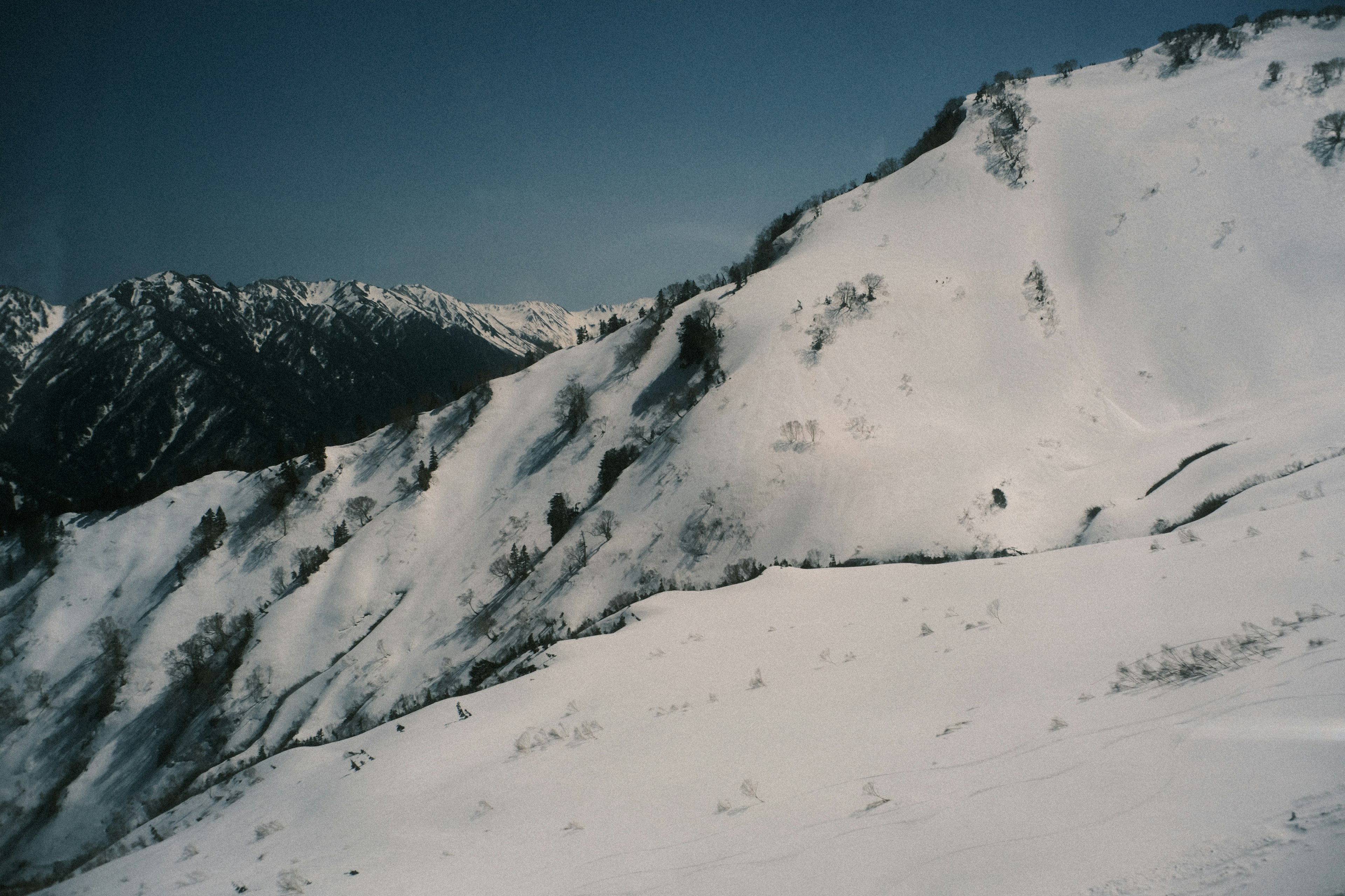 Snow-covered mountains with a clear blue sky