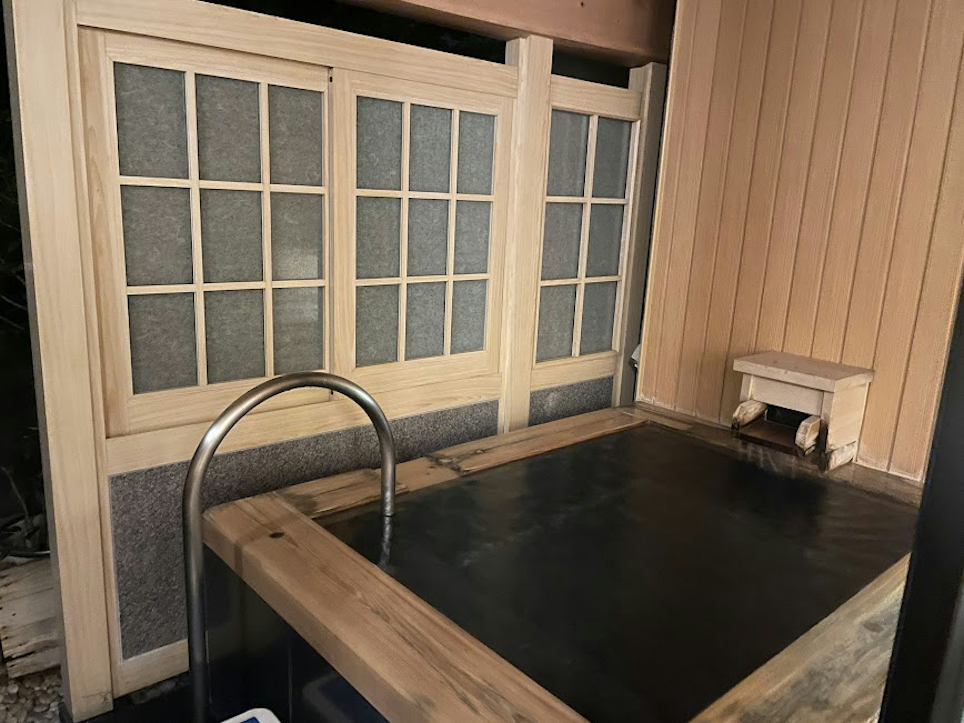 Wooden soaking tub with glass-paneled walls in a relaxing space