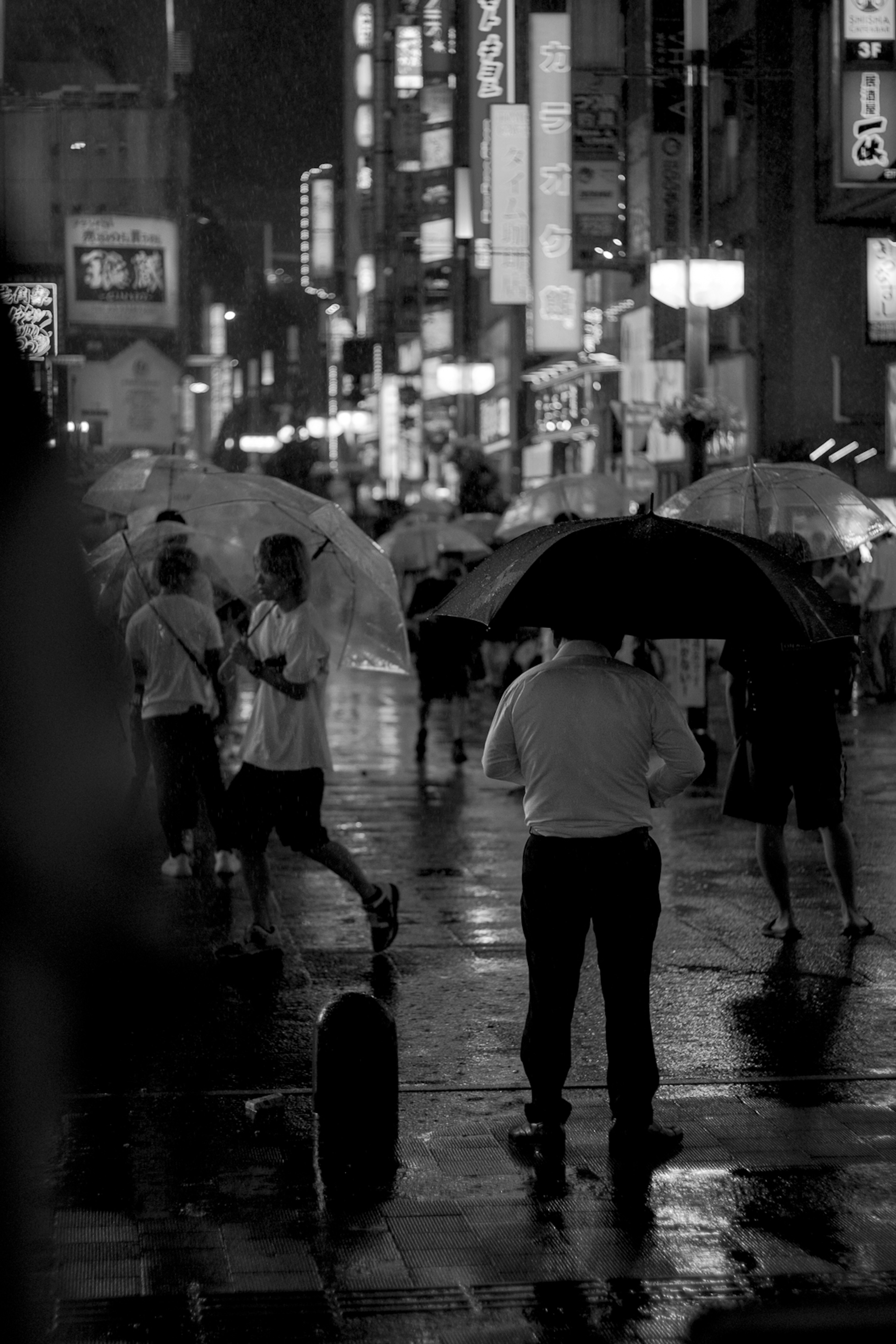 Scène urbaine sous la pluie personnes tenant des parapluies photo en noir et blanc