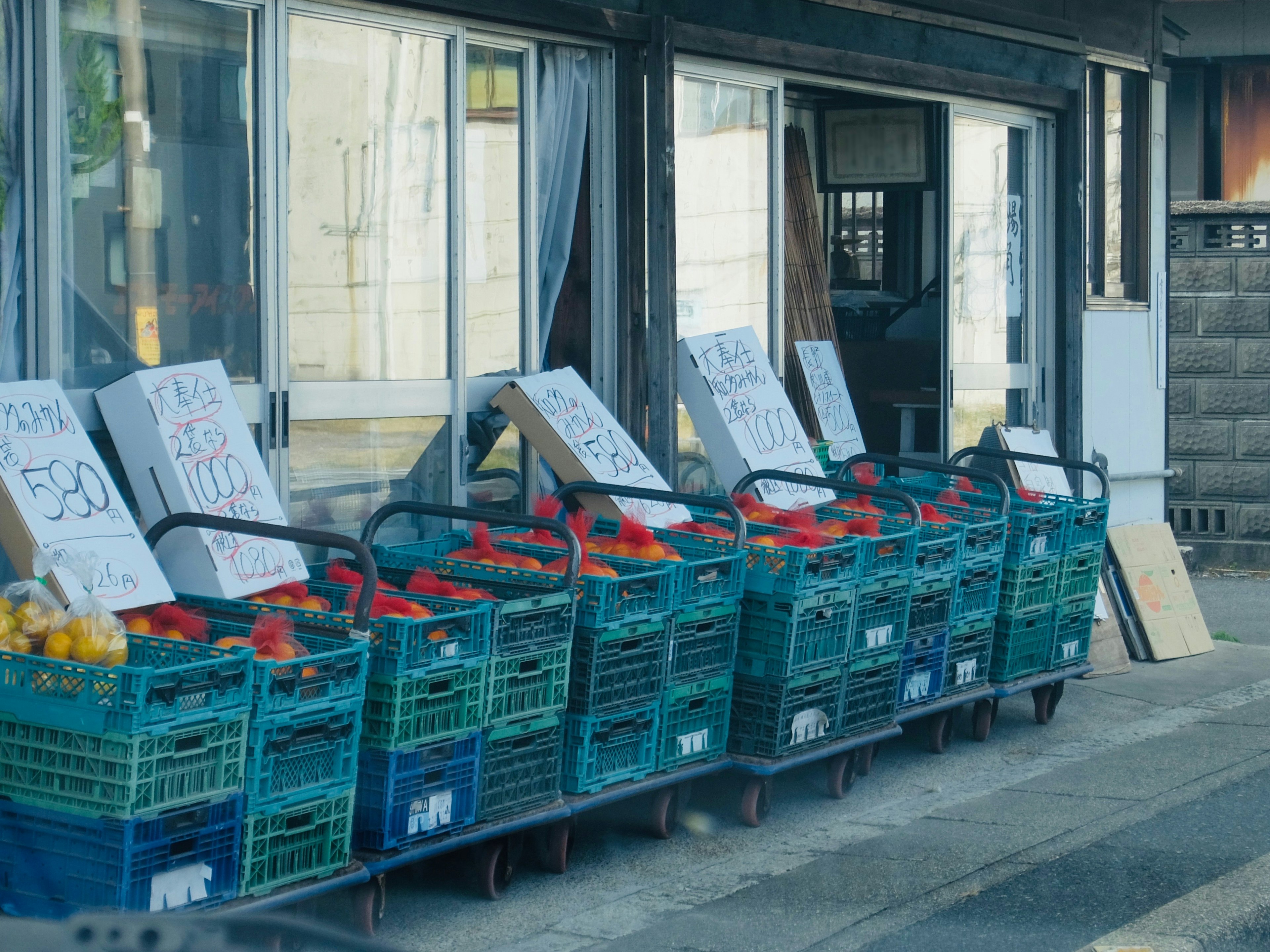 Vue extérieure d'un stand de rue avec des fruits colorés dans des paniers bleus