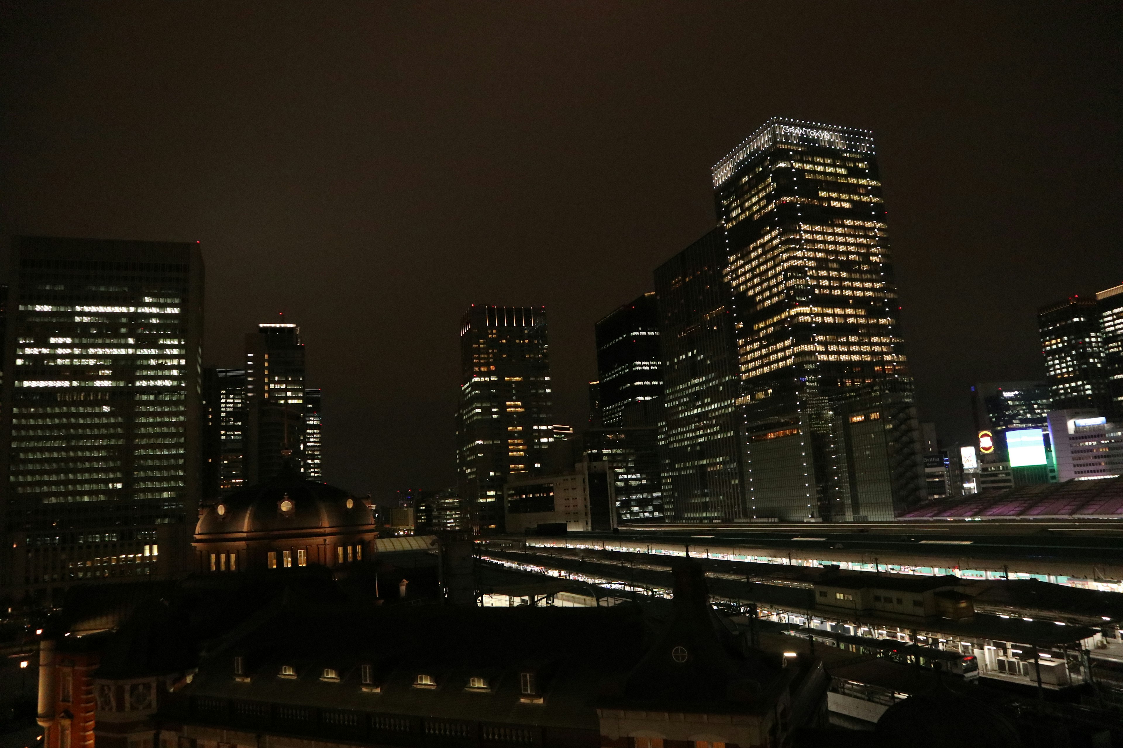 Pemandangan kota malam hari dengan gedung pencakar langit yang diterangi