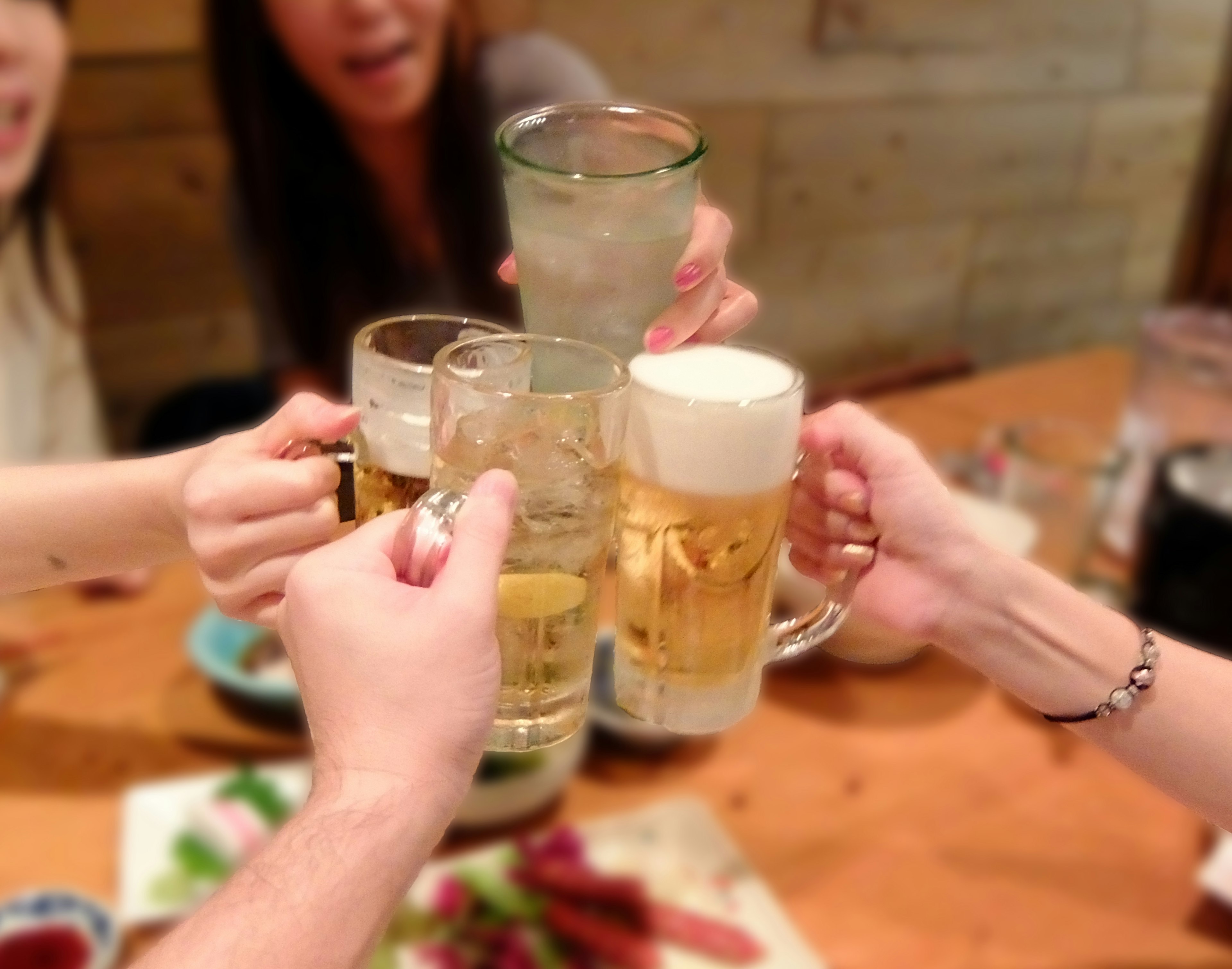 Group of friends toasting with beer and drinks at a table