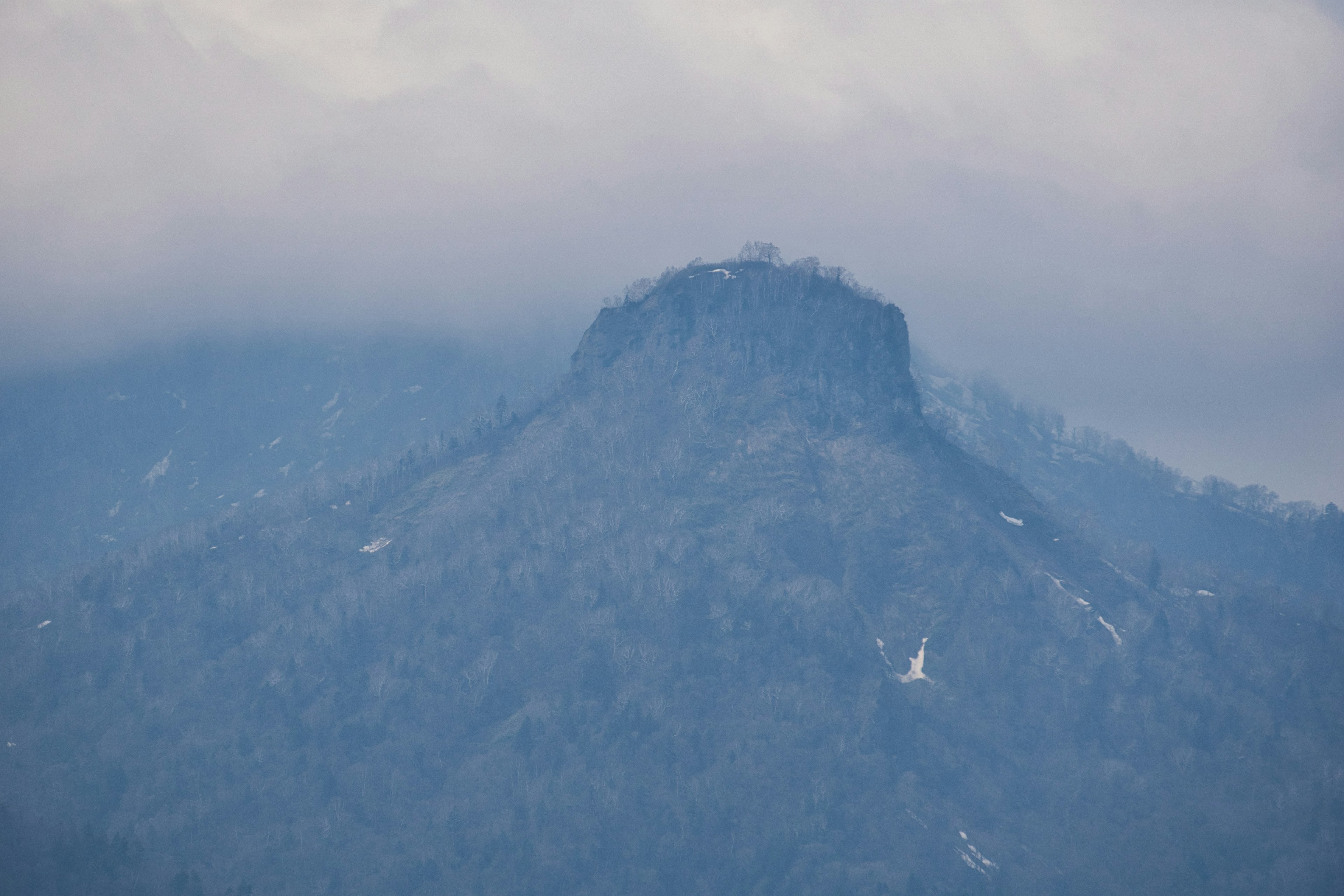 A mountain peak shrouded in mist and clouds