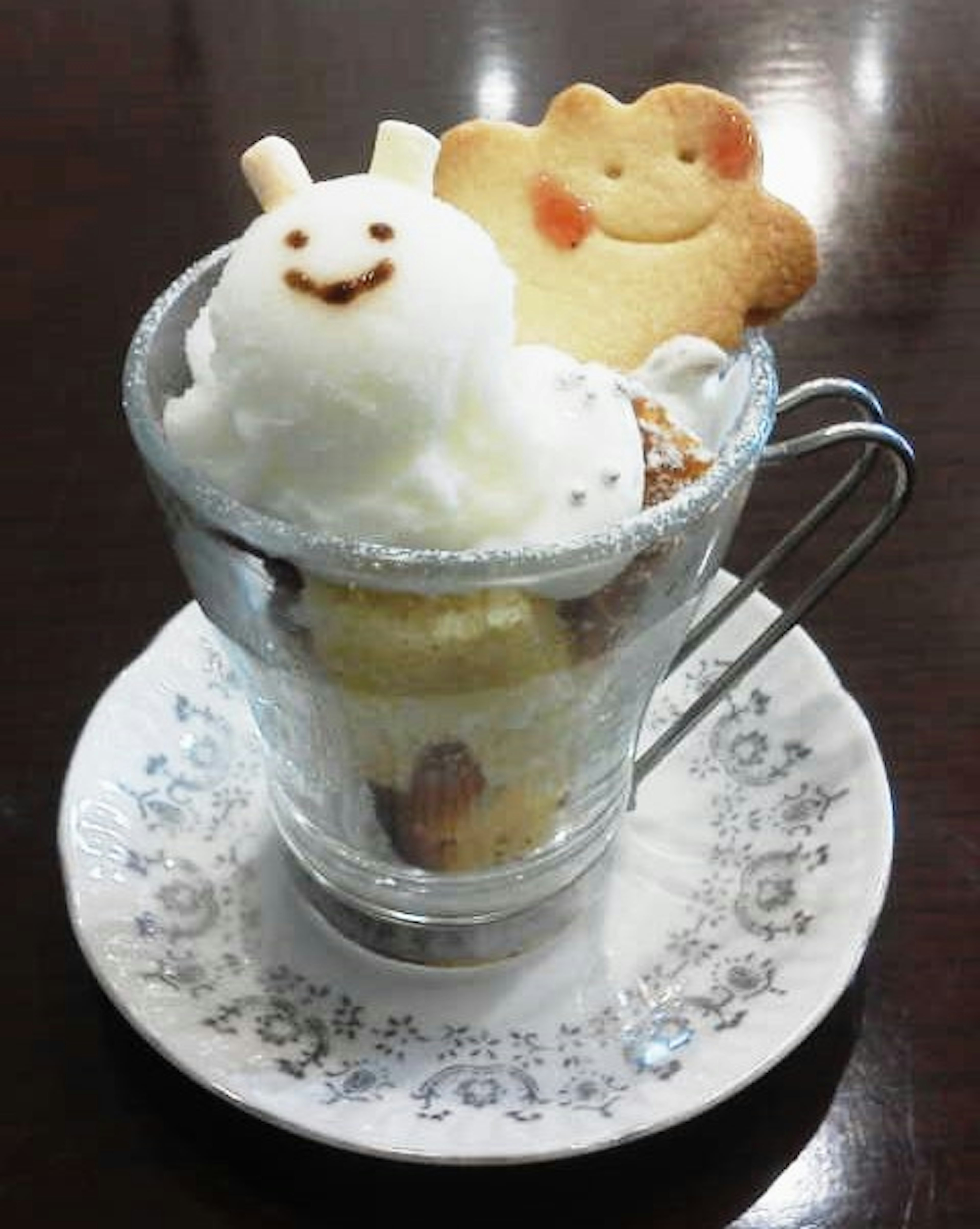 Galleta sonriente y helado en una taza de vidrio