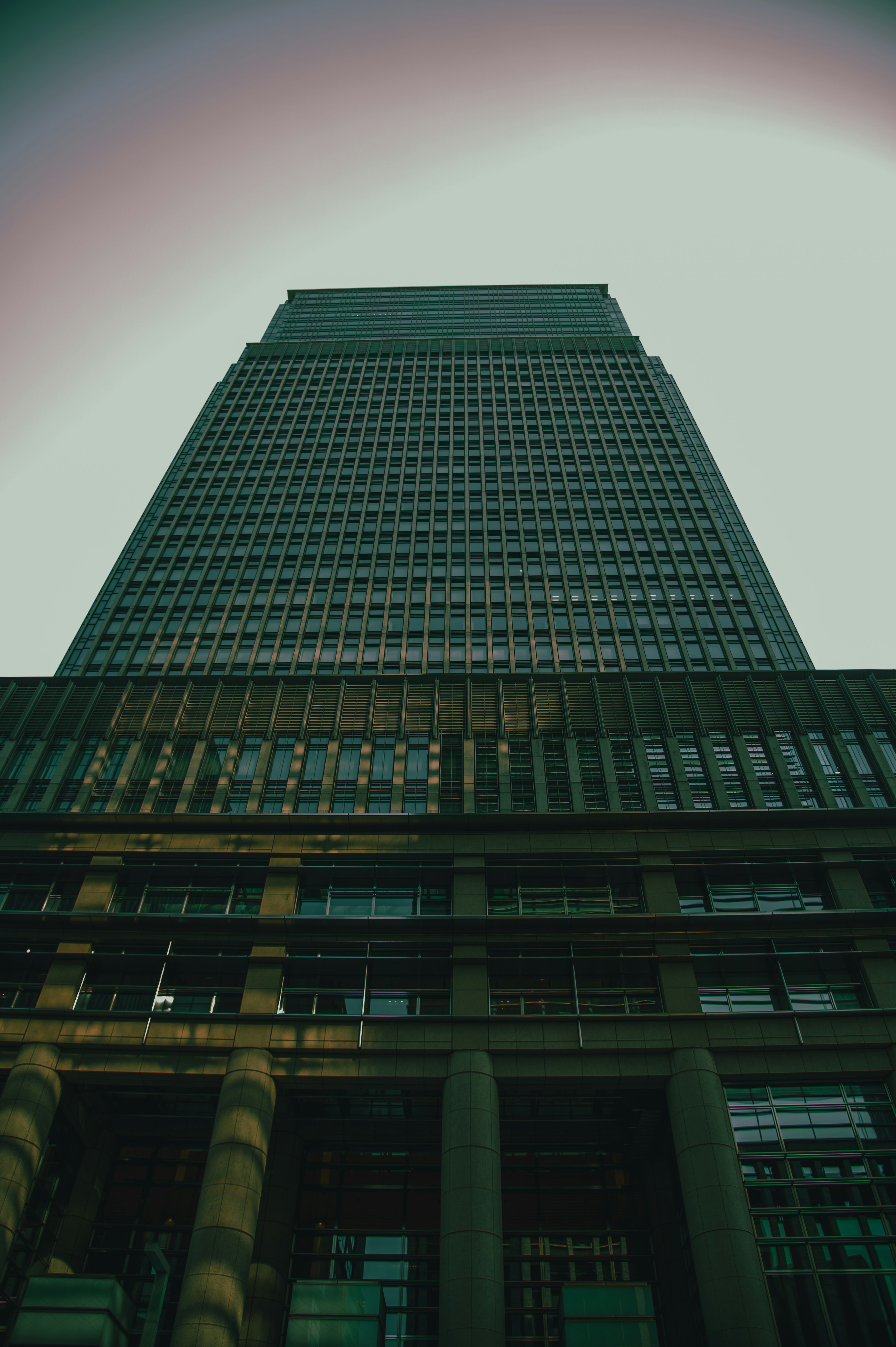 Perspective view of a skyscraper looking up with clouds at the top