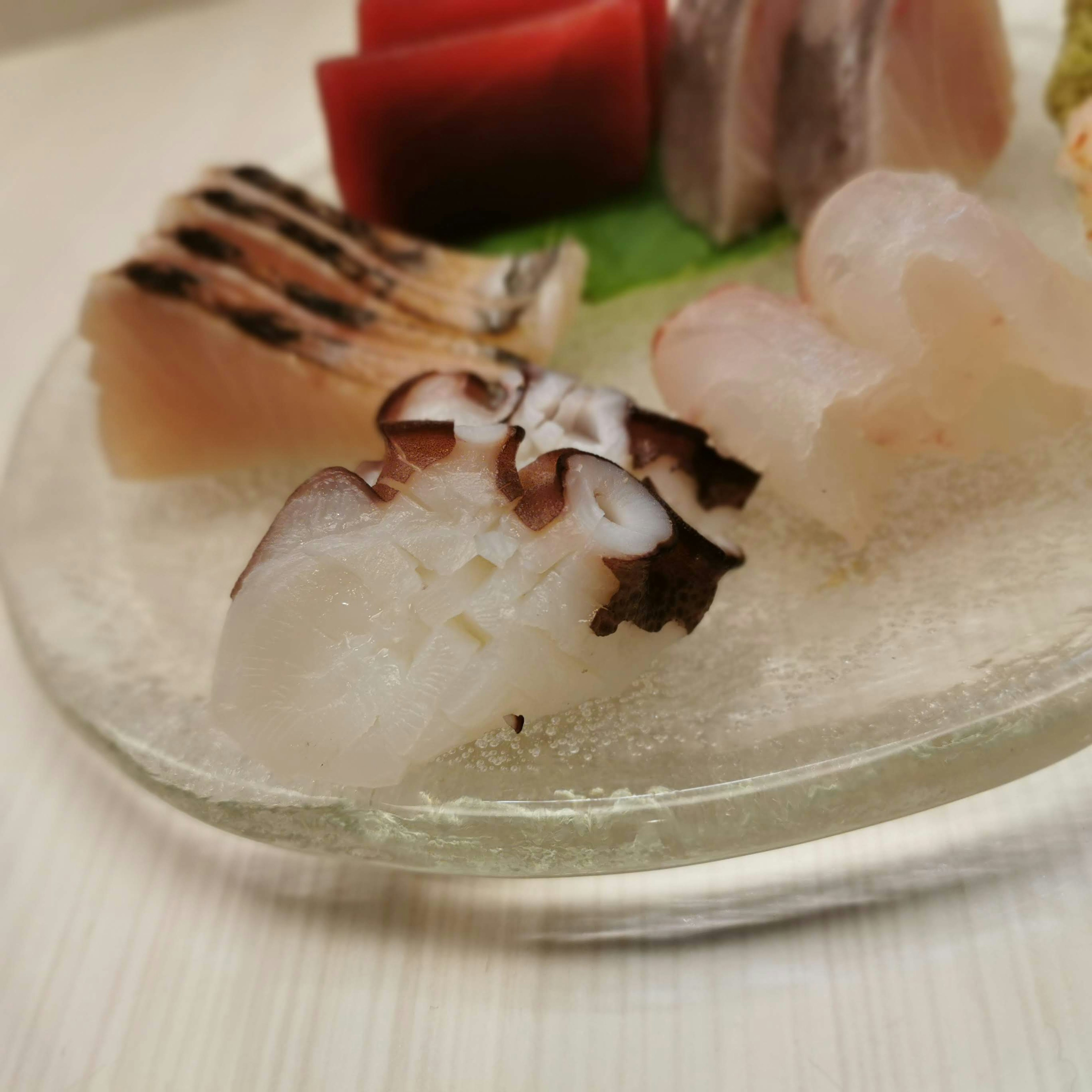 A beautifully arranged plate of fresh sashimi including various types of fish