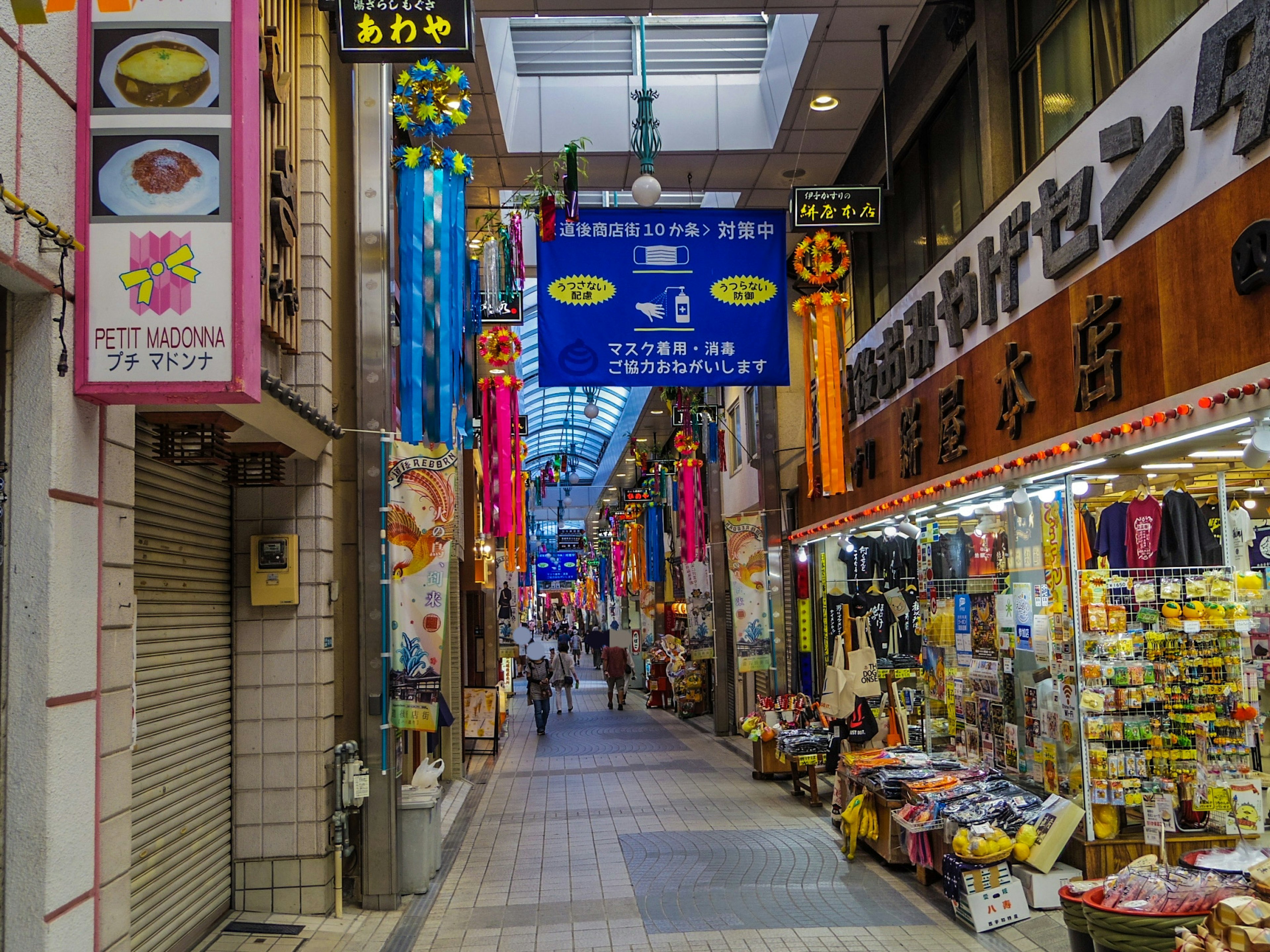 Rue commerçante animée avec des bannières colorées et des boutiques le long du chemin