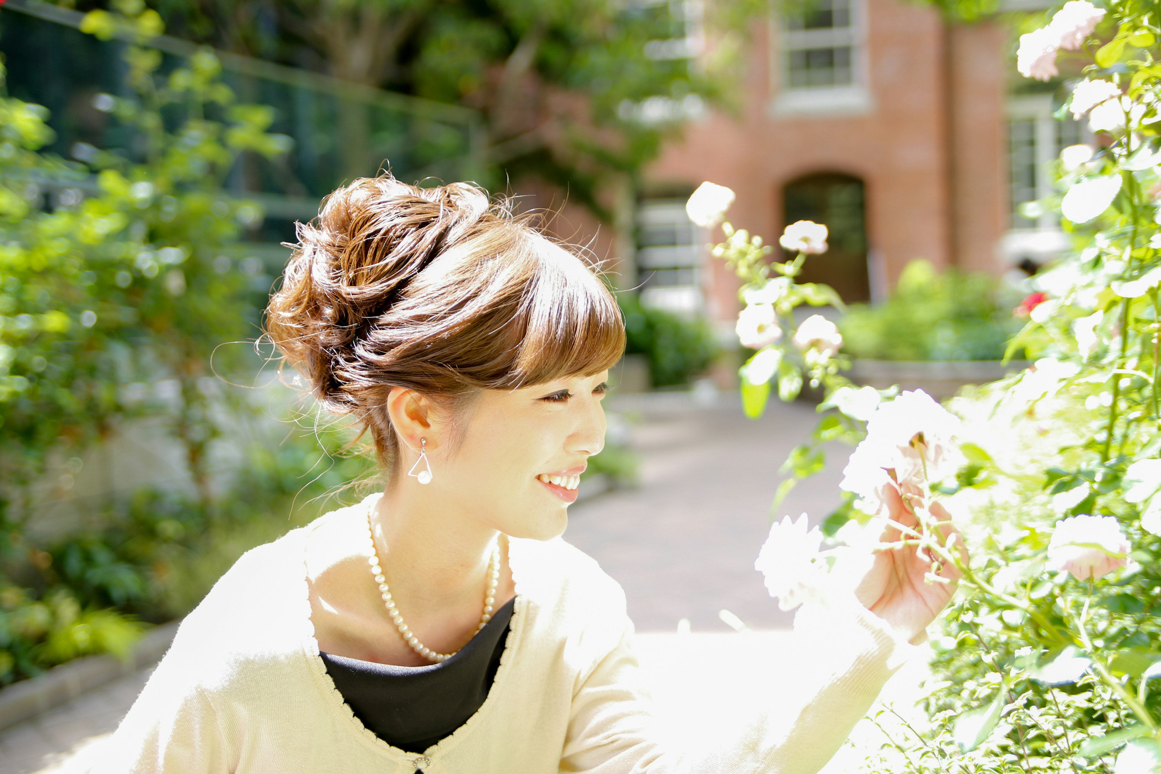 Una donna sorridente che raccoglie fiori in un giardino