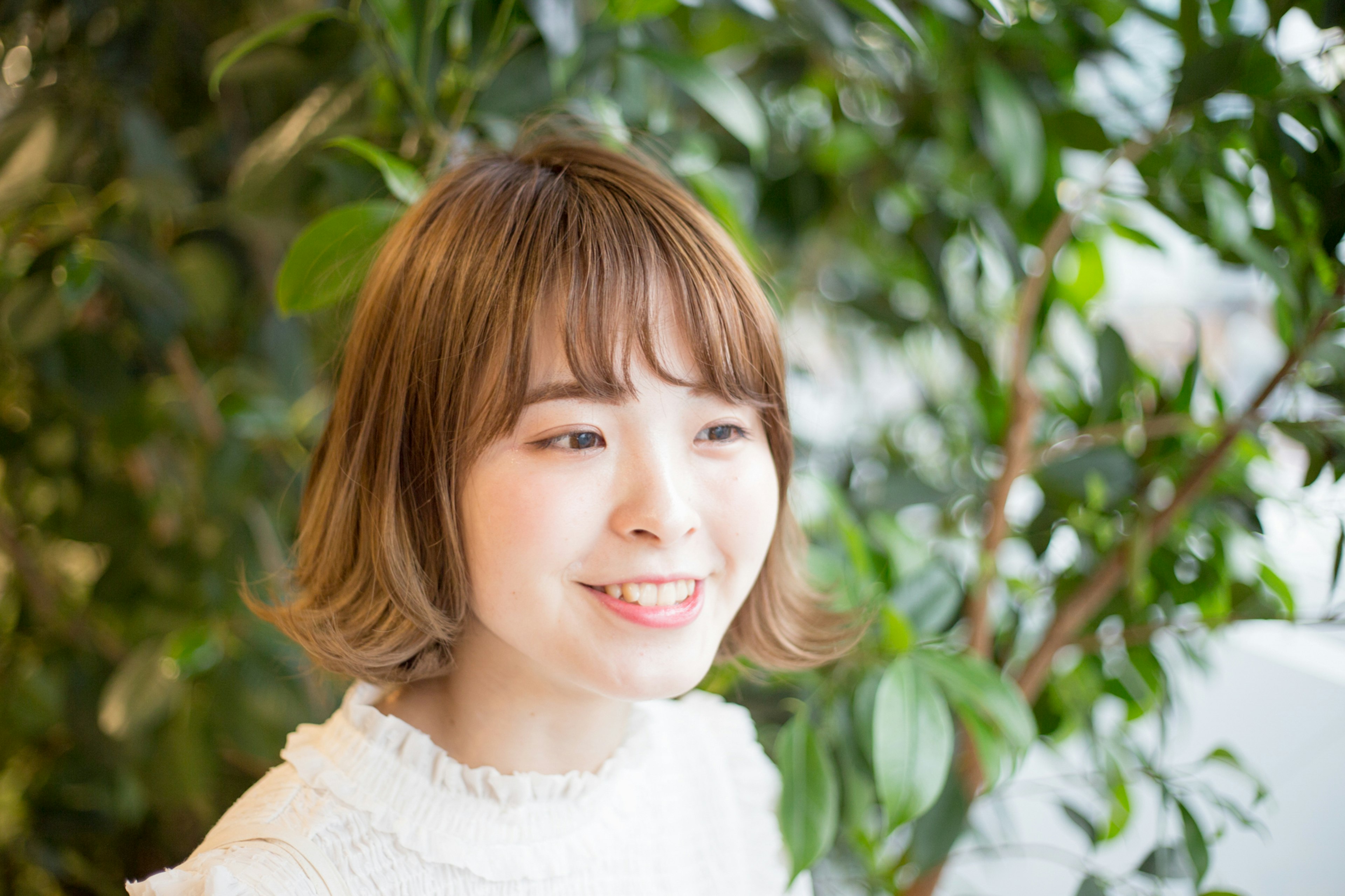 Mujer joven sonriendo frente a plantas