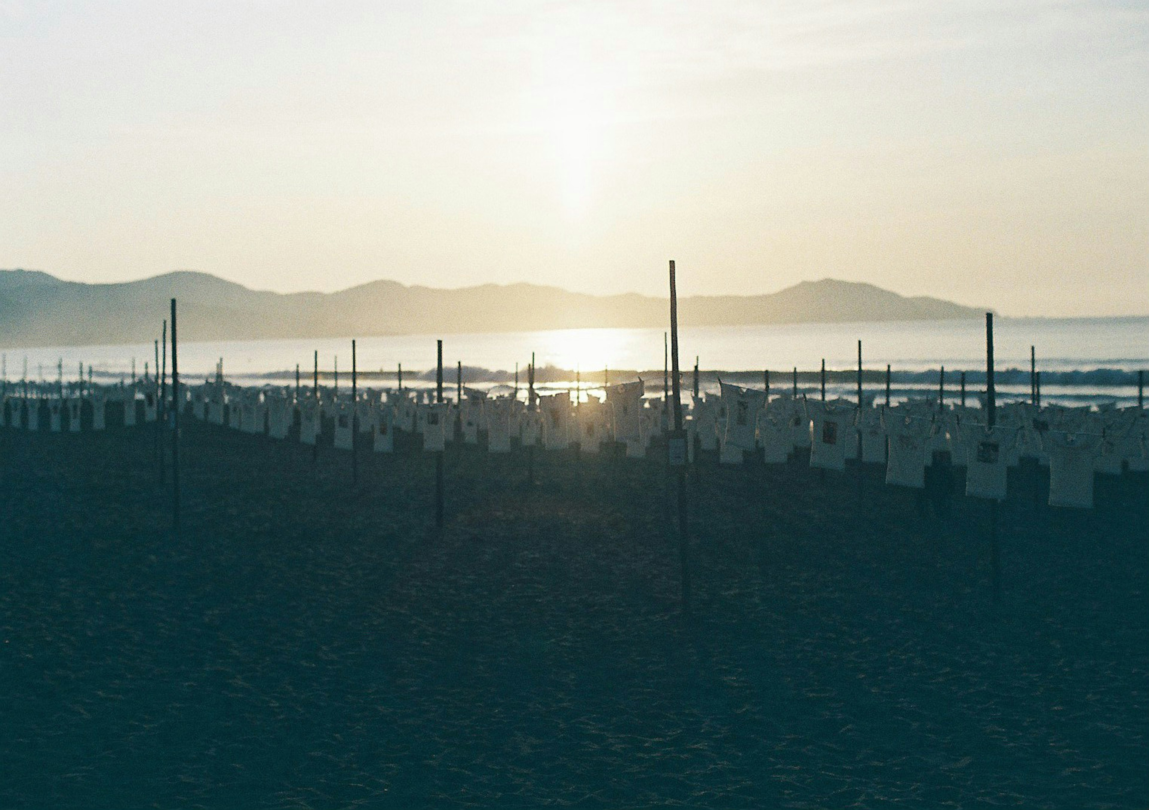 เงาของภูเขาและทะเลในยามเช้าพร้อมวัตถุเรียงรายบนชายหาด