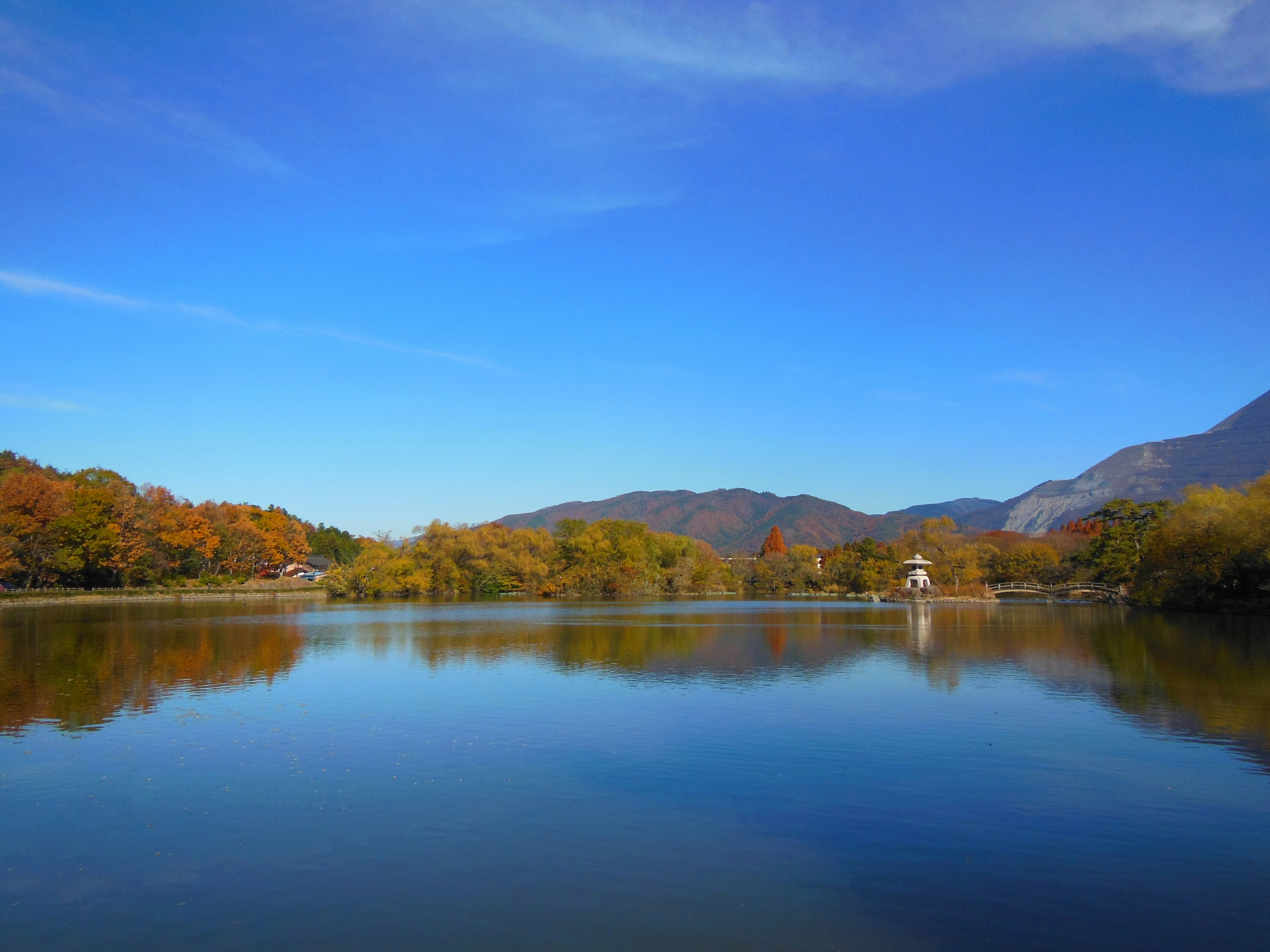 Lac serein entouré de montagnes sous un ciel bleu clair