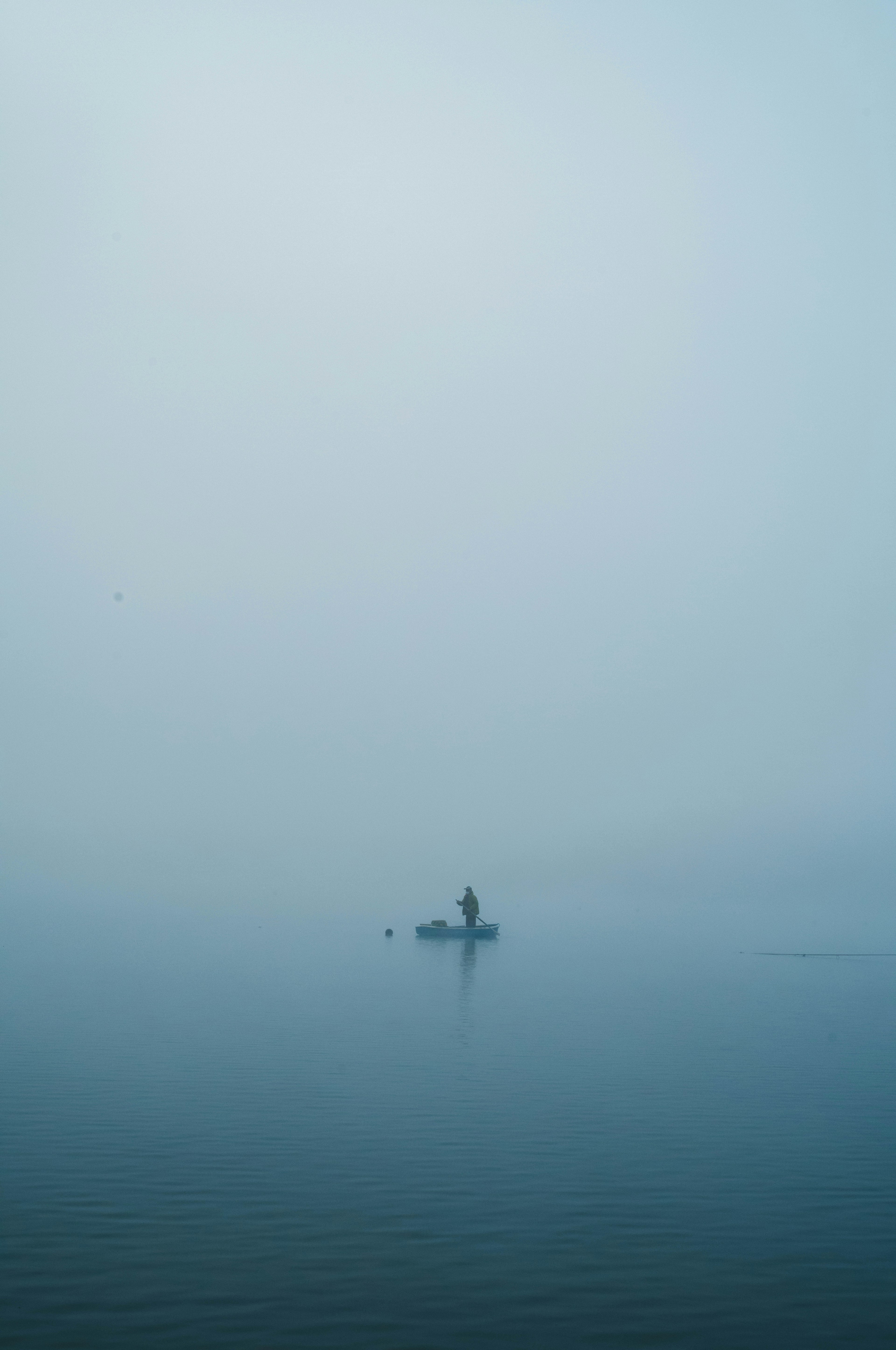 A small island in fog with a person standing on it