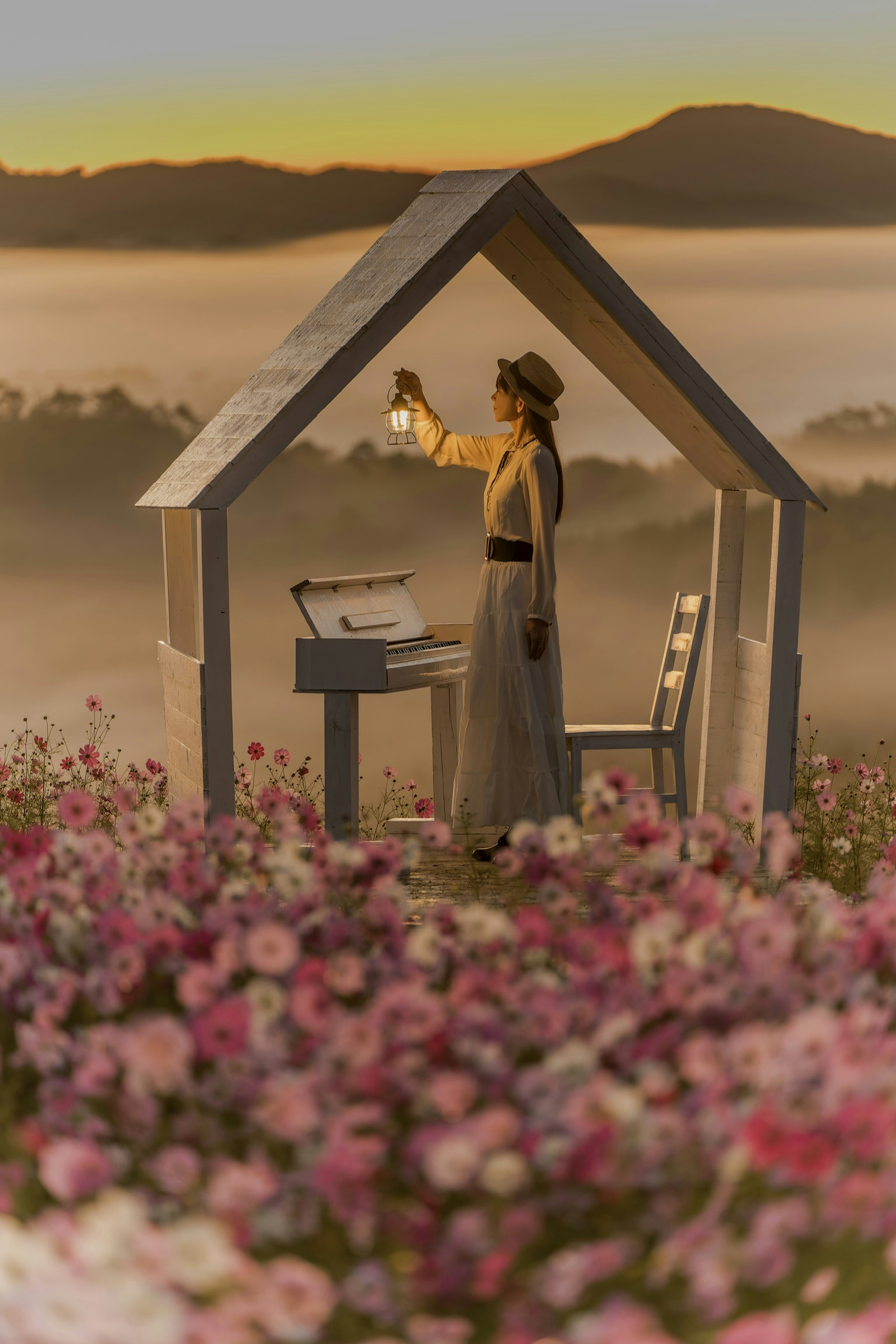 A woman holding a lantern inside a small house surrounded by flowers