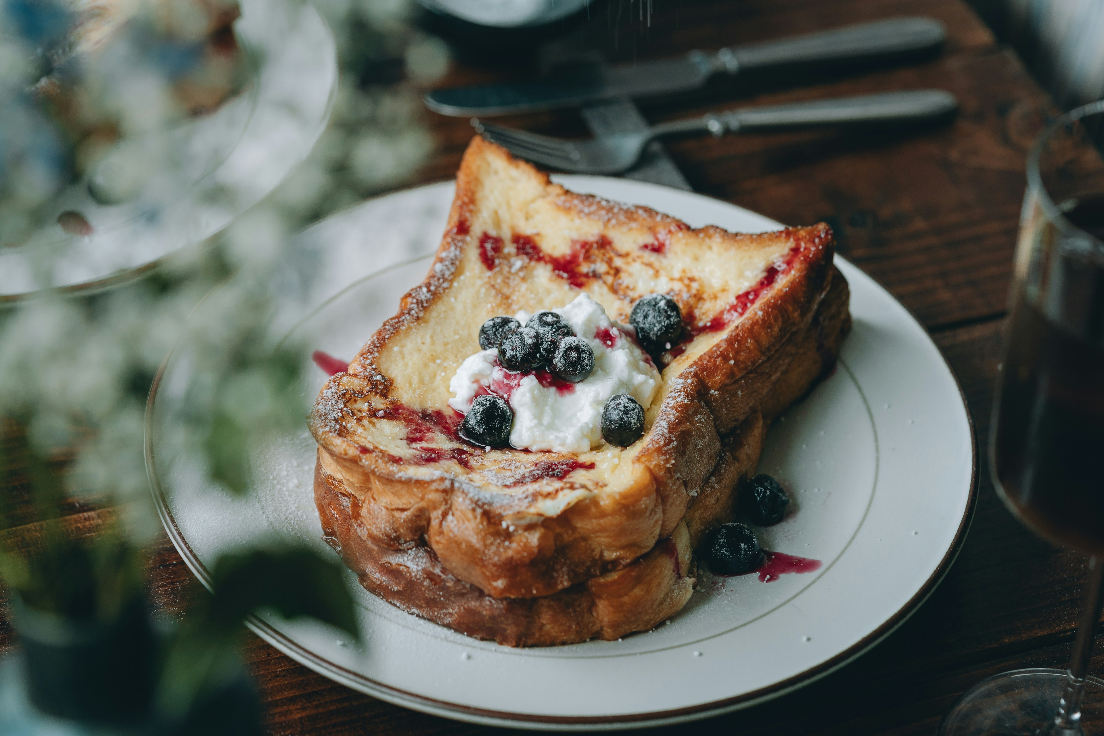 Plate of French toast topped with blueberries and cream