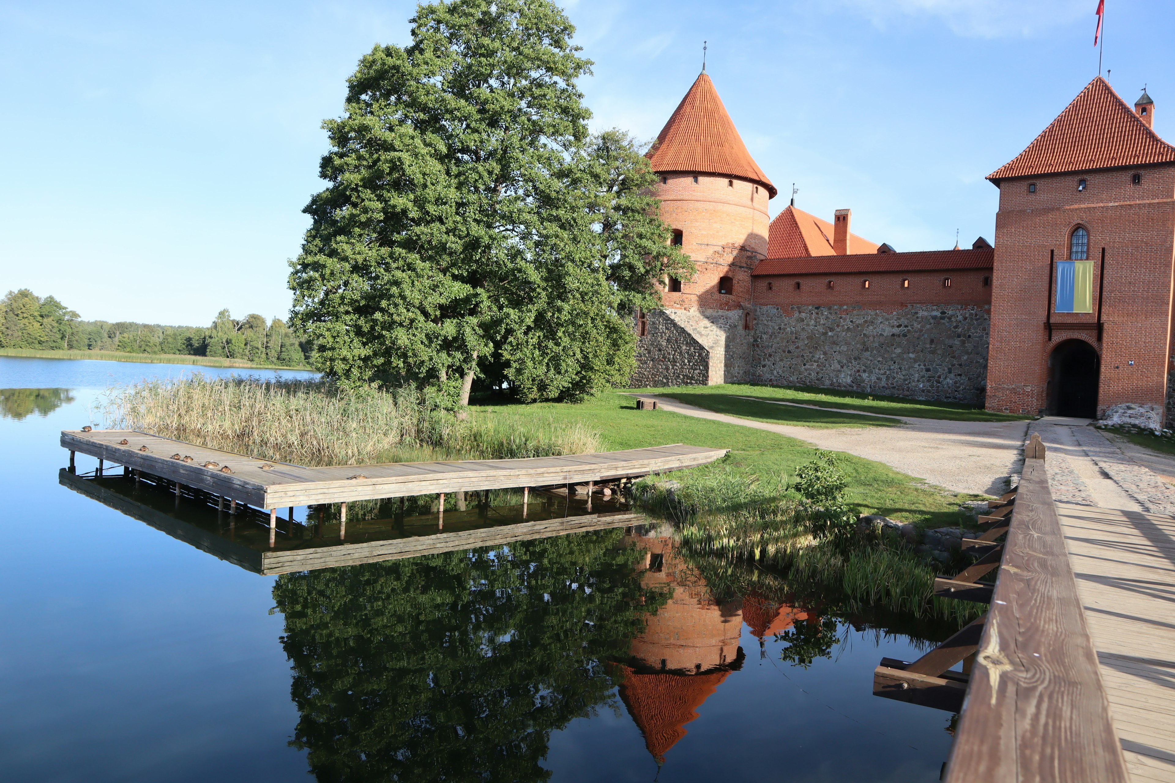 Pemandangan indah Kastil Trakai dengan pantulan di danau dan pepohonan di sekitarnya