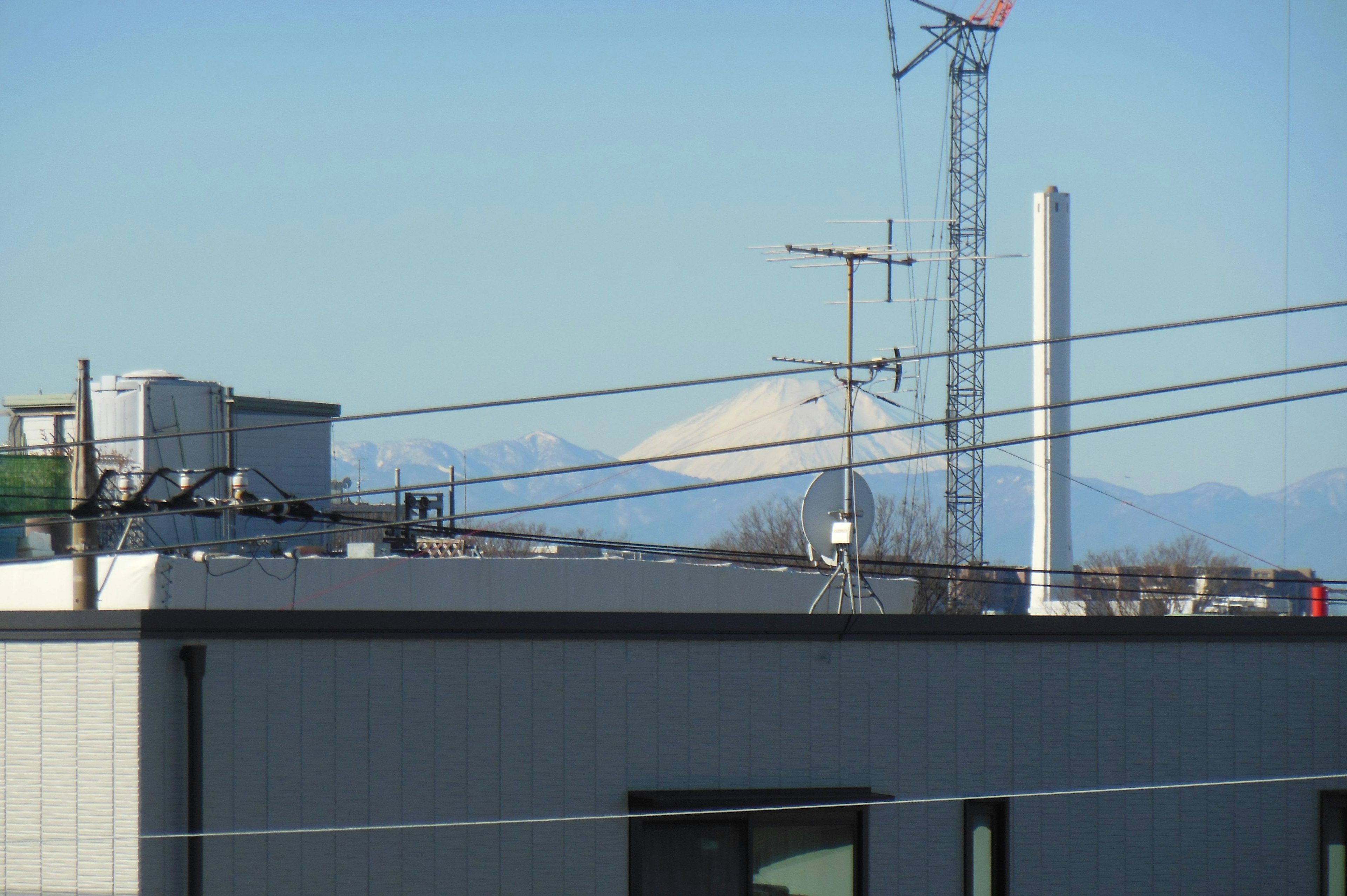 View of mountains under a clear blue sky with buildings in the foreground