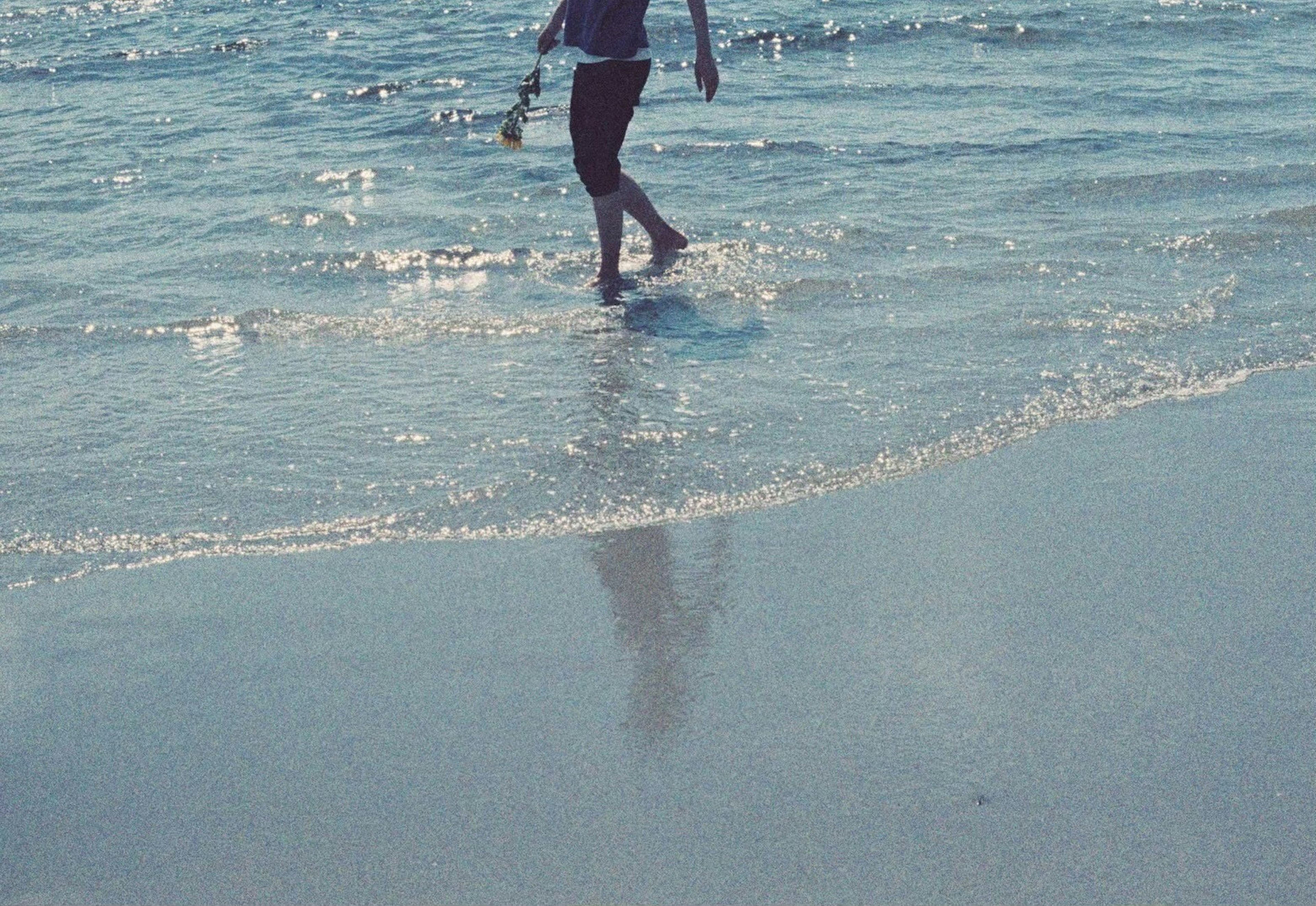 Persona che cammina lungo la riva con onde oceaniche