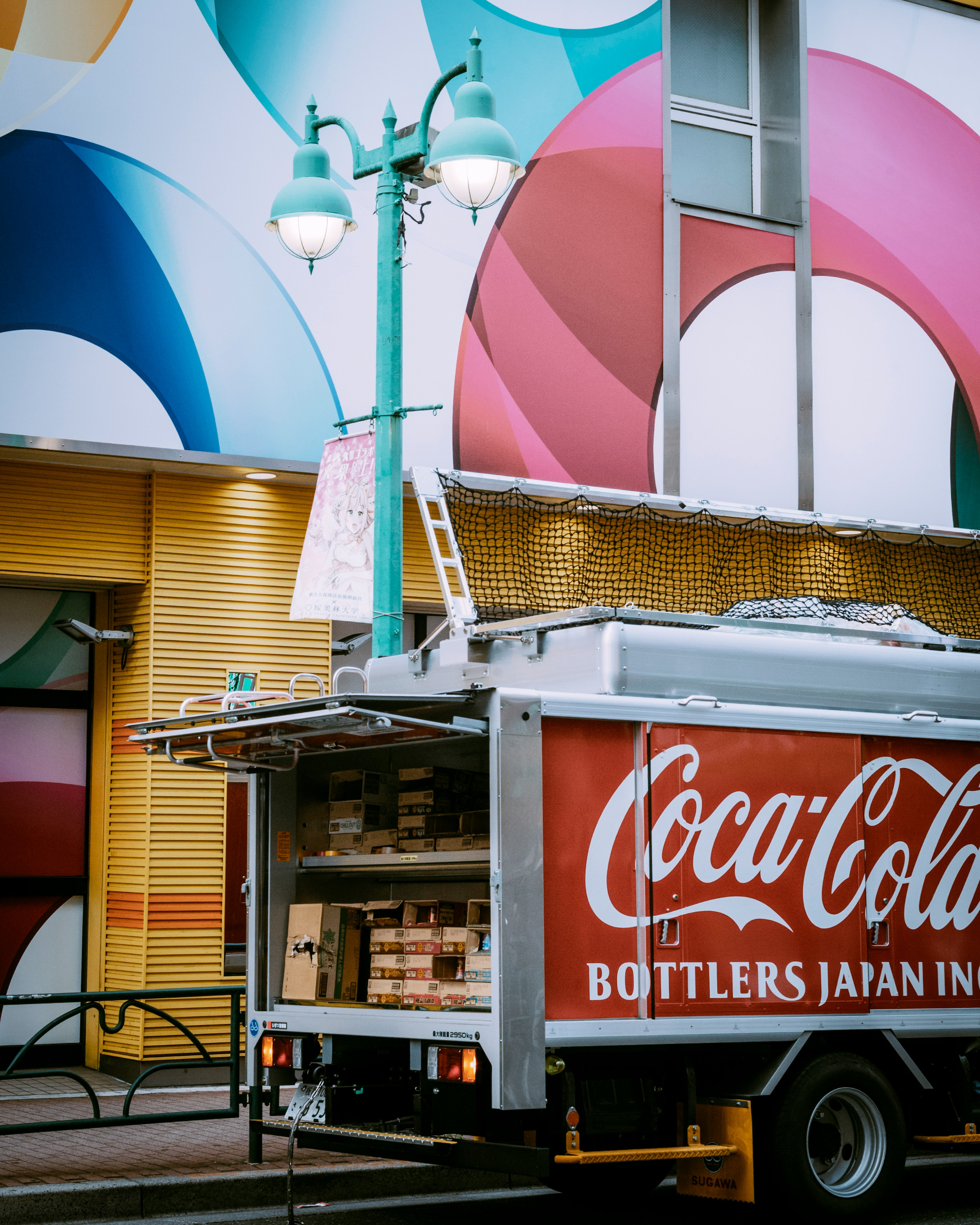 Camion Coca-Cola parcheggiato di fronte a un muro colorato