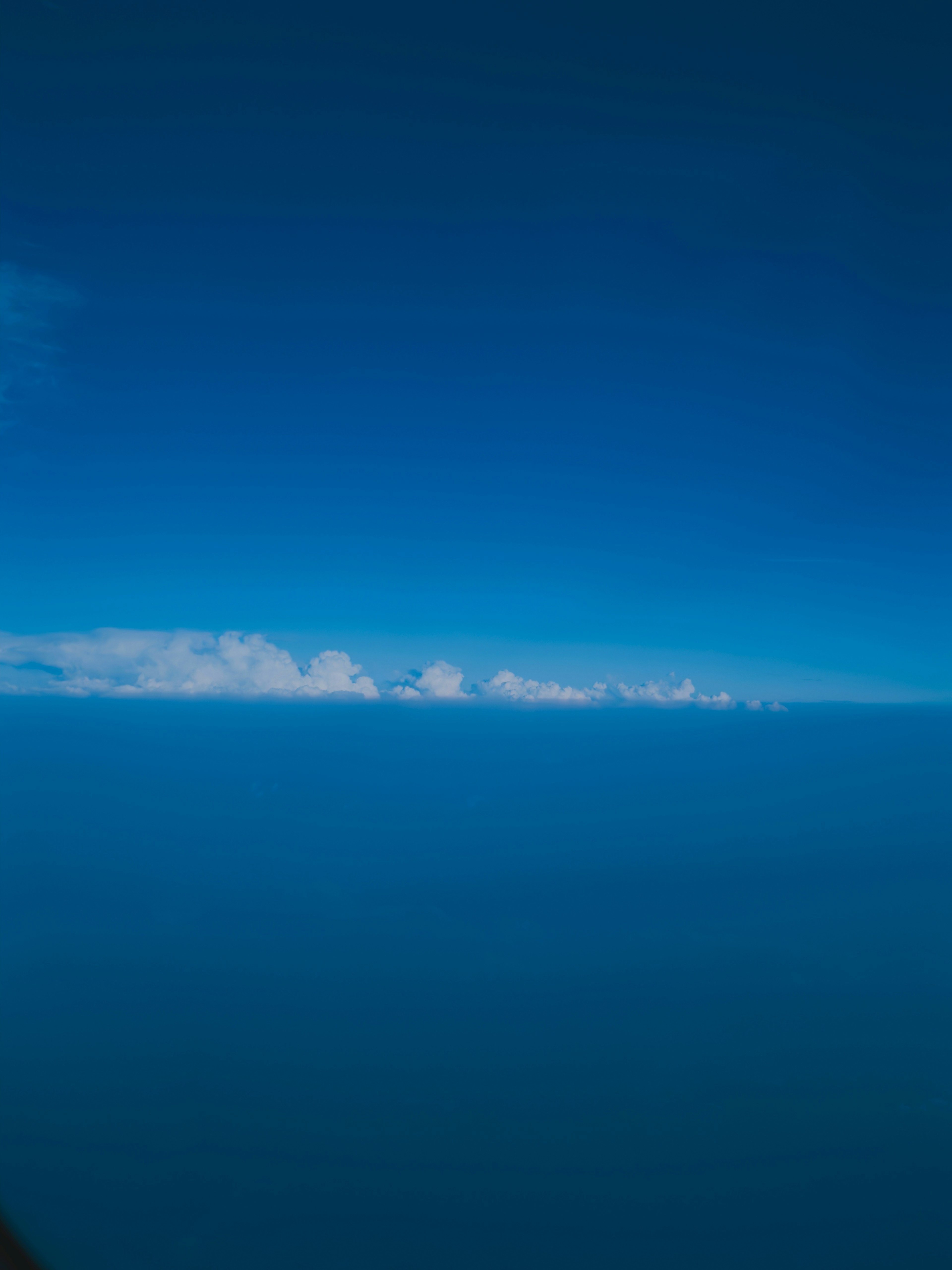 Vast blue sky with a line of clouds on the horizon