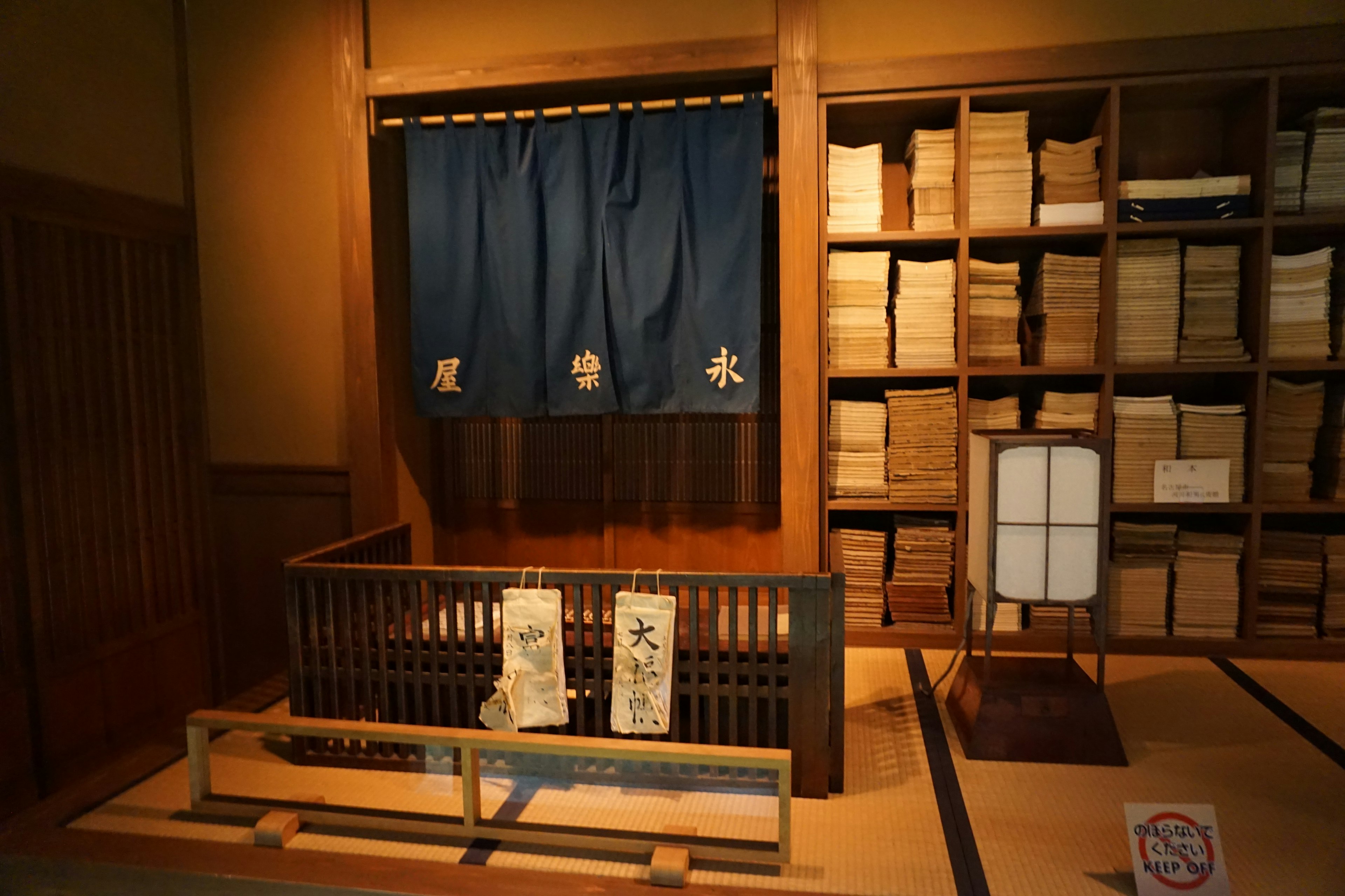 Traditional Japanese room featuring wooden furniture and a blue noren curtain