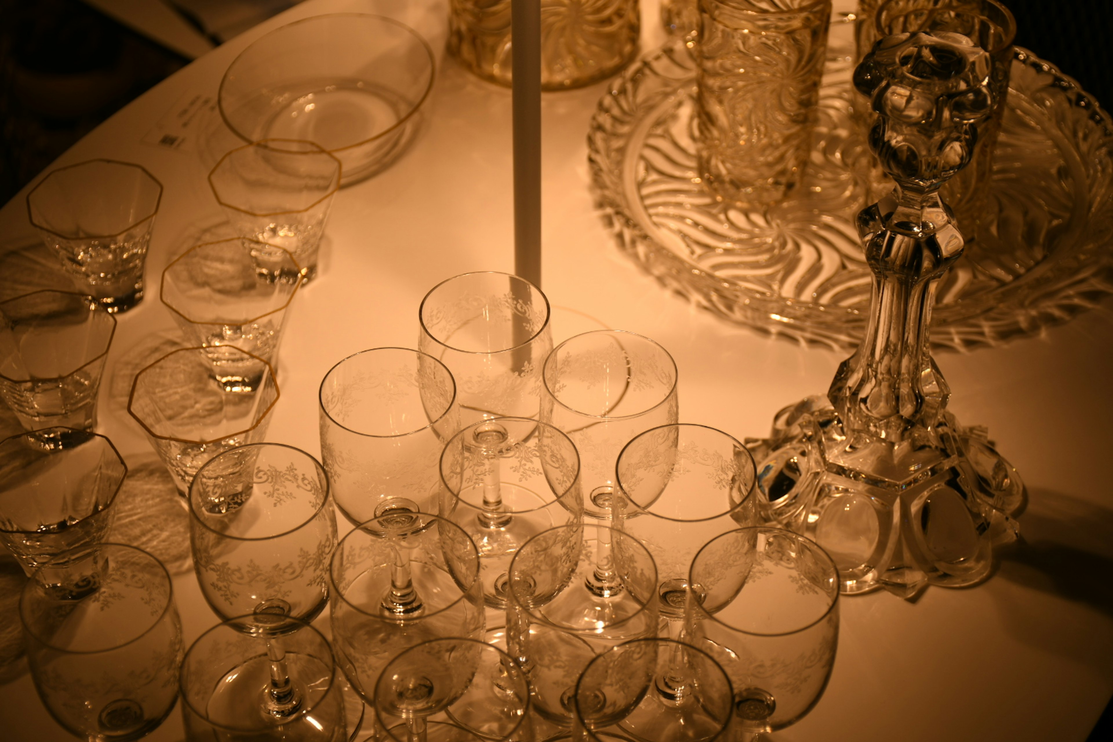 Arranged clear glasses and a candle holder on a table