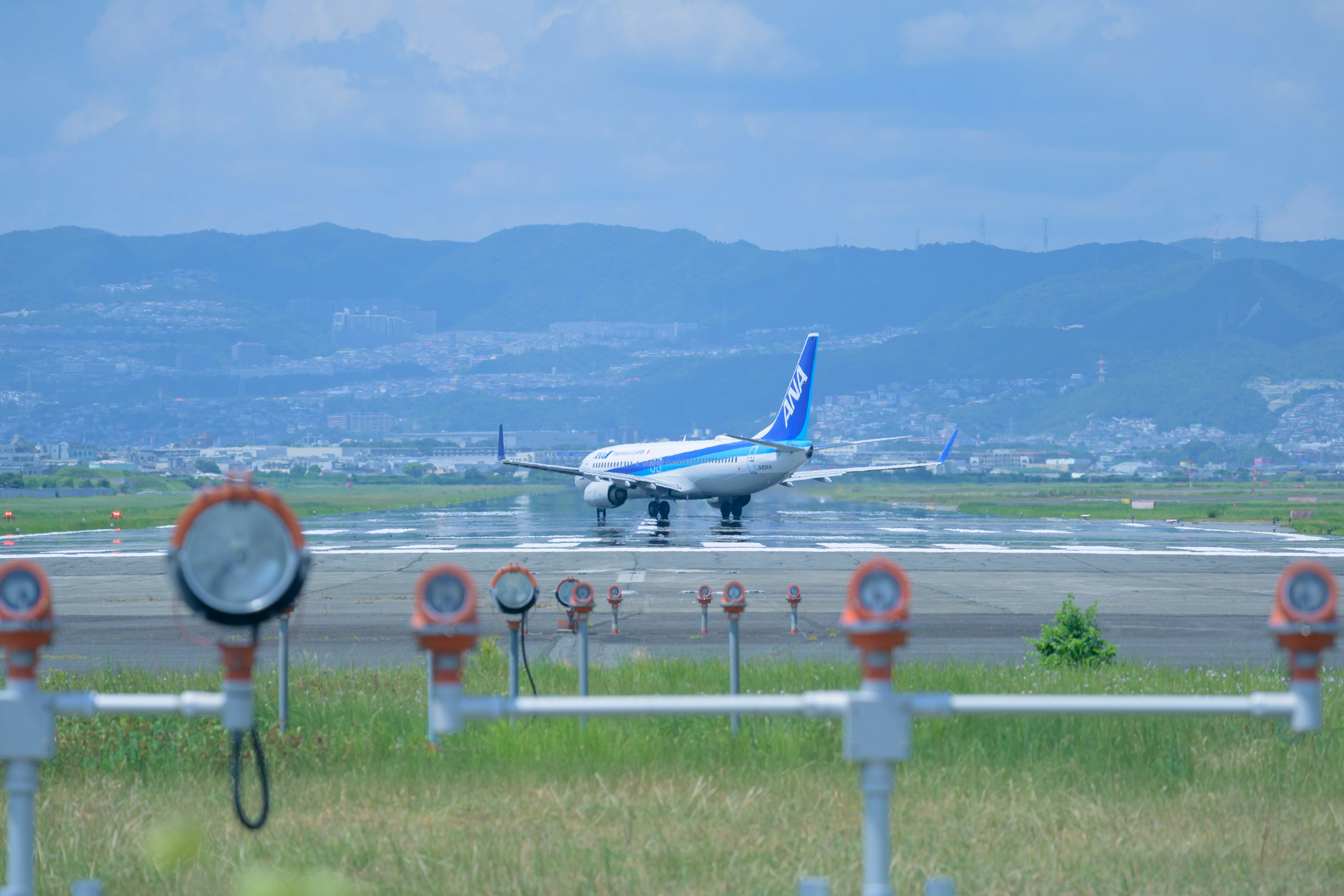 Avion atterrissant sur la piste avec ciel bleu en arrière-plan et marqueurs de piste