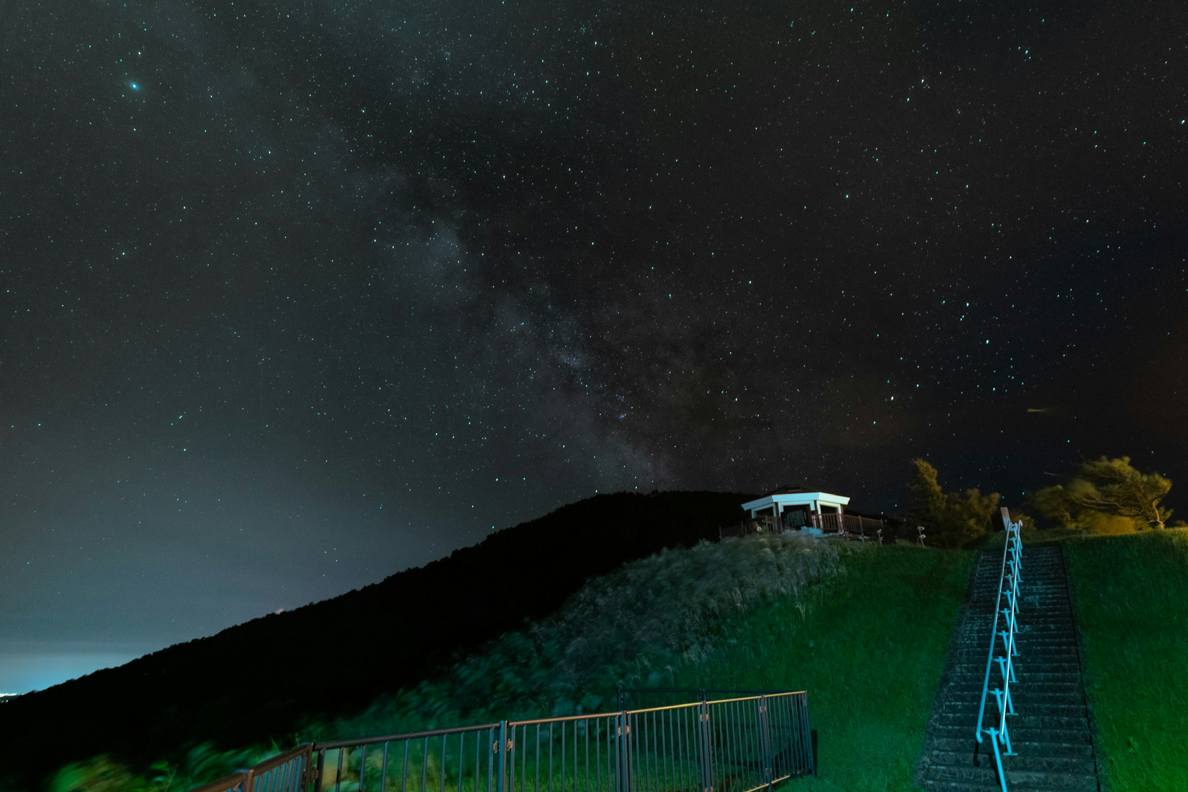 星空の下の丘と階段が見える美しい夜の風景