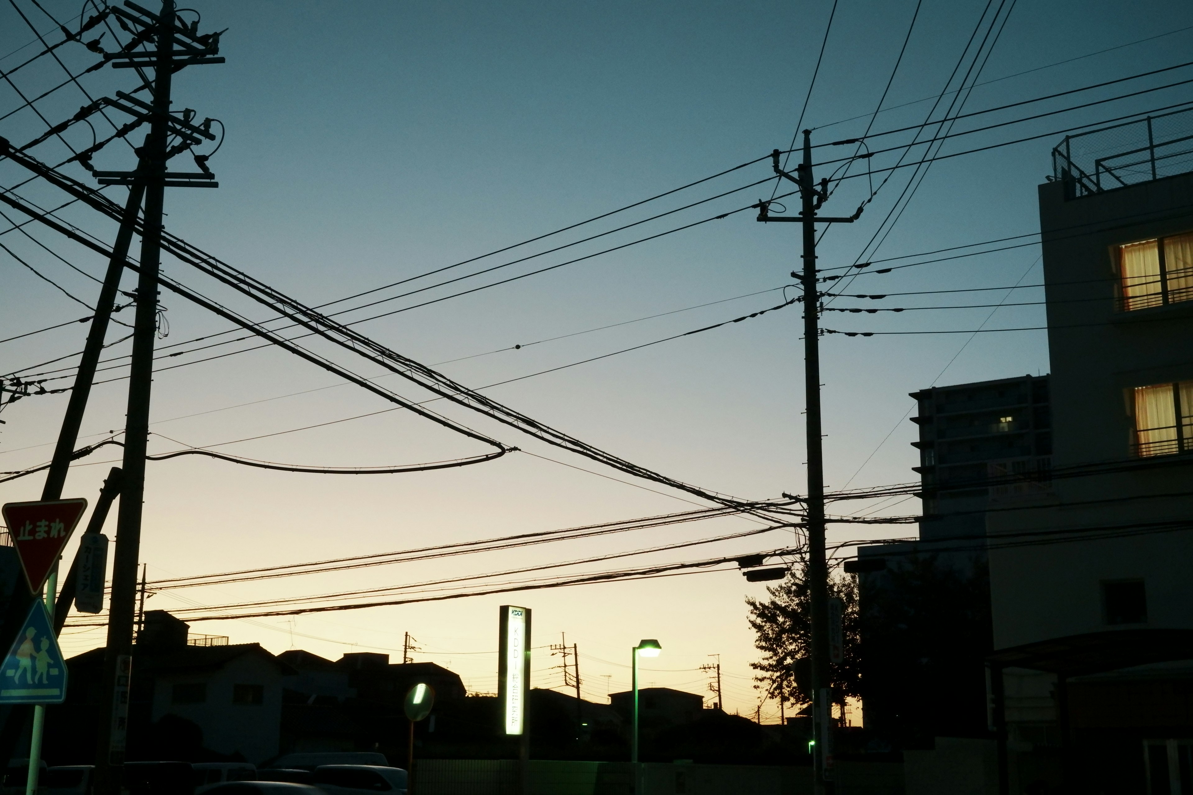 Silhouette of power lines and buildings at dusk