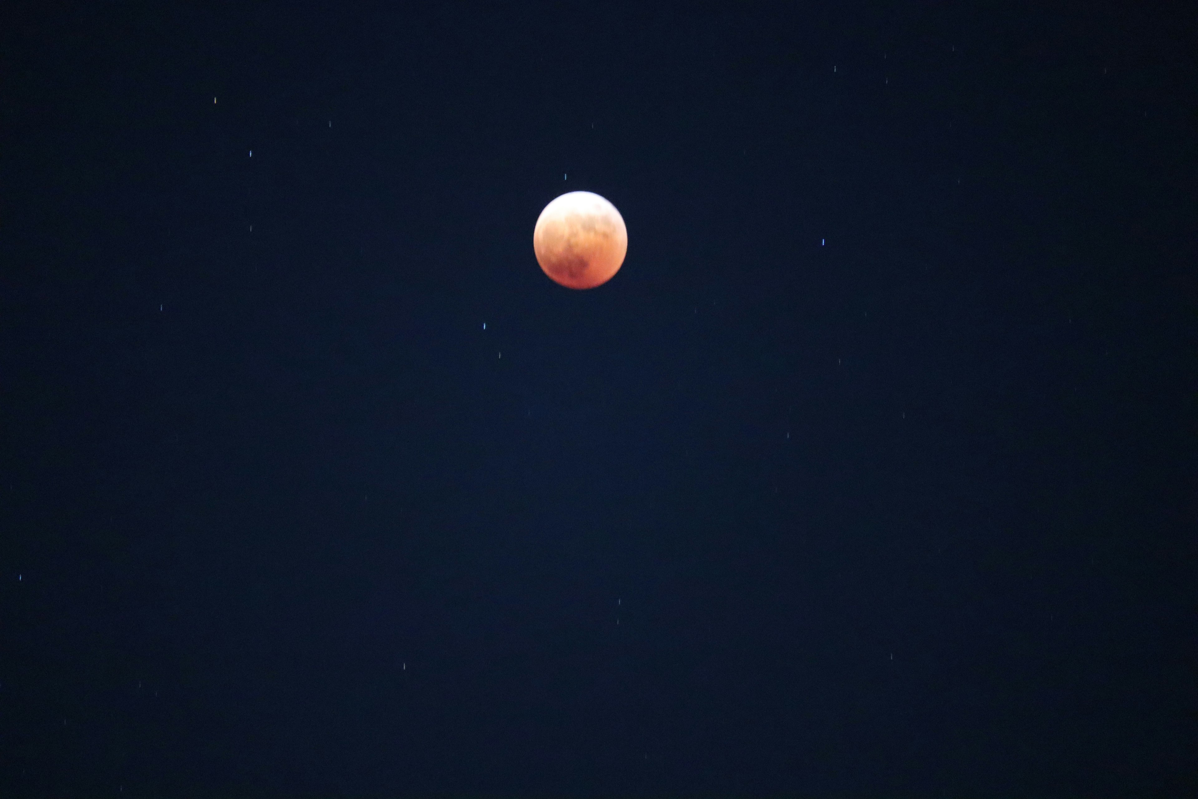 Red moon and stars in the night sky