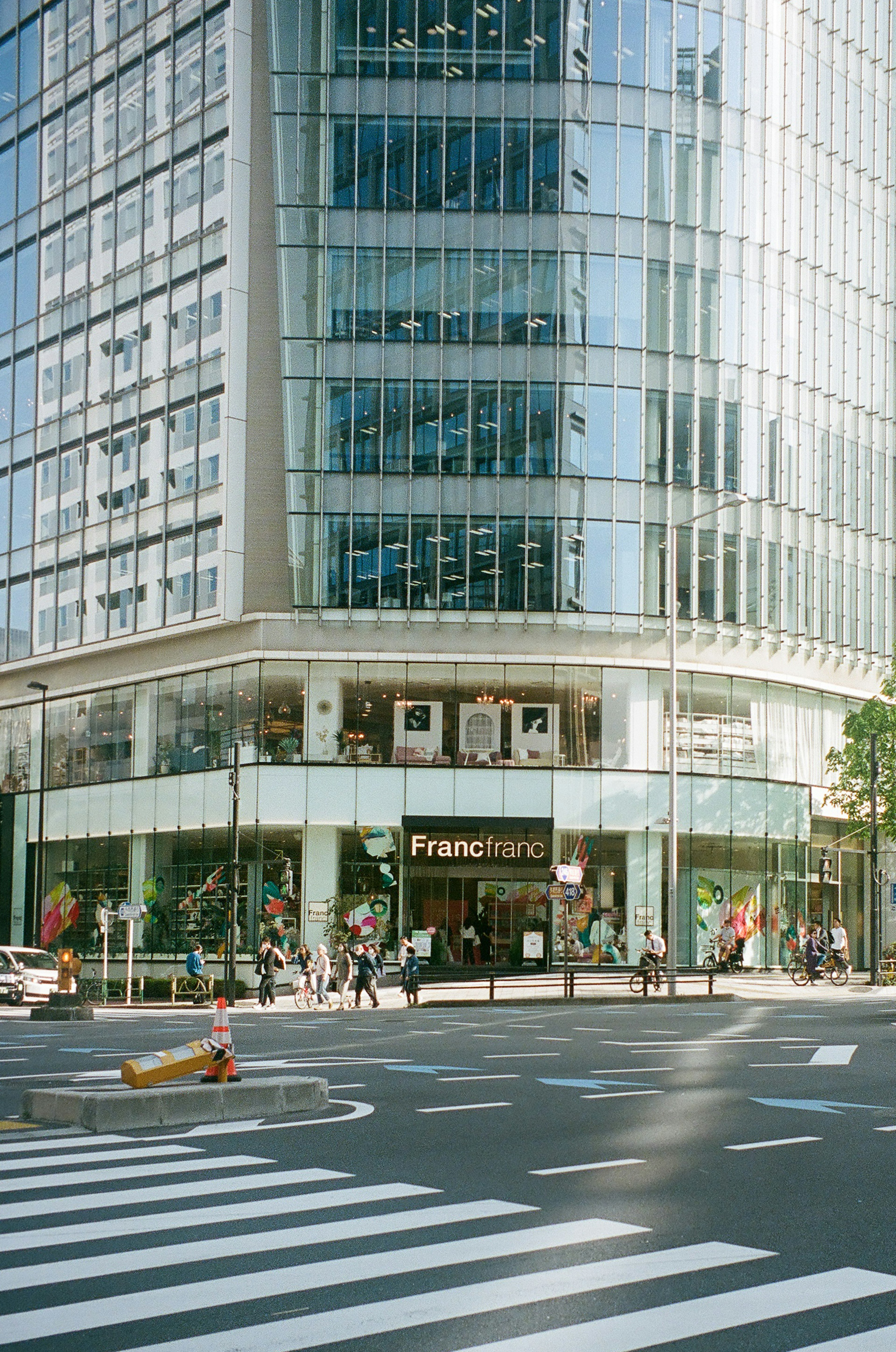 Modern glass building corner featuring a fashion store entrance