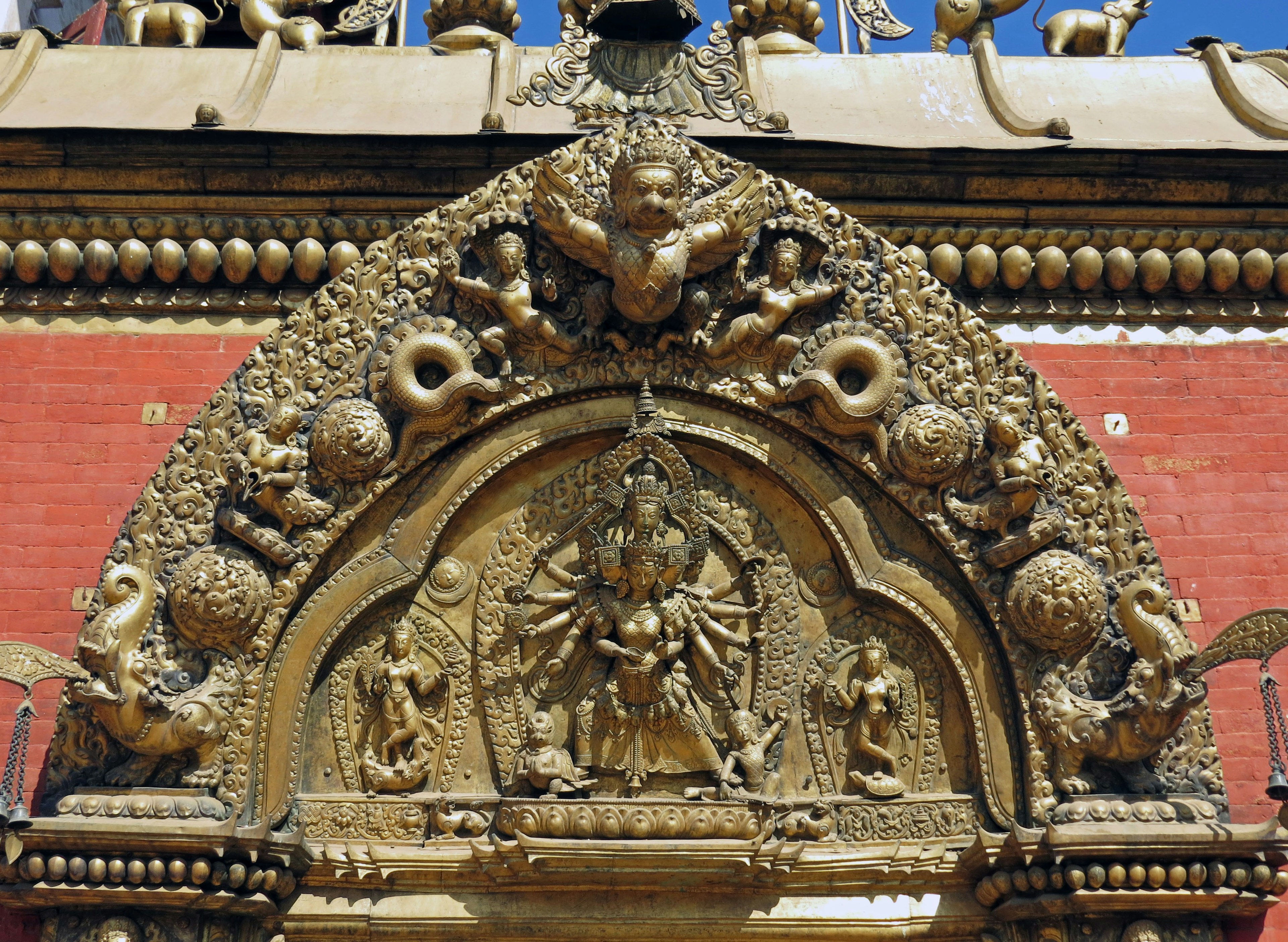 Intricate temple sculpture featuring deities and ornate designs