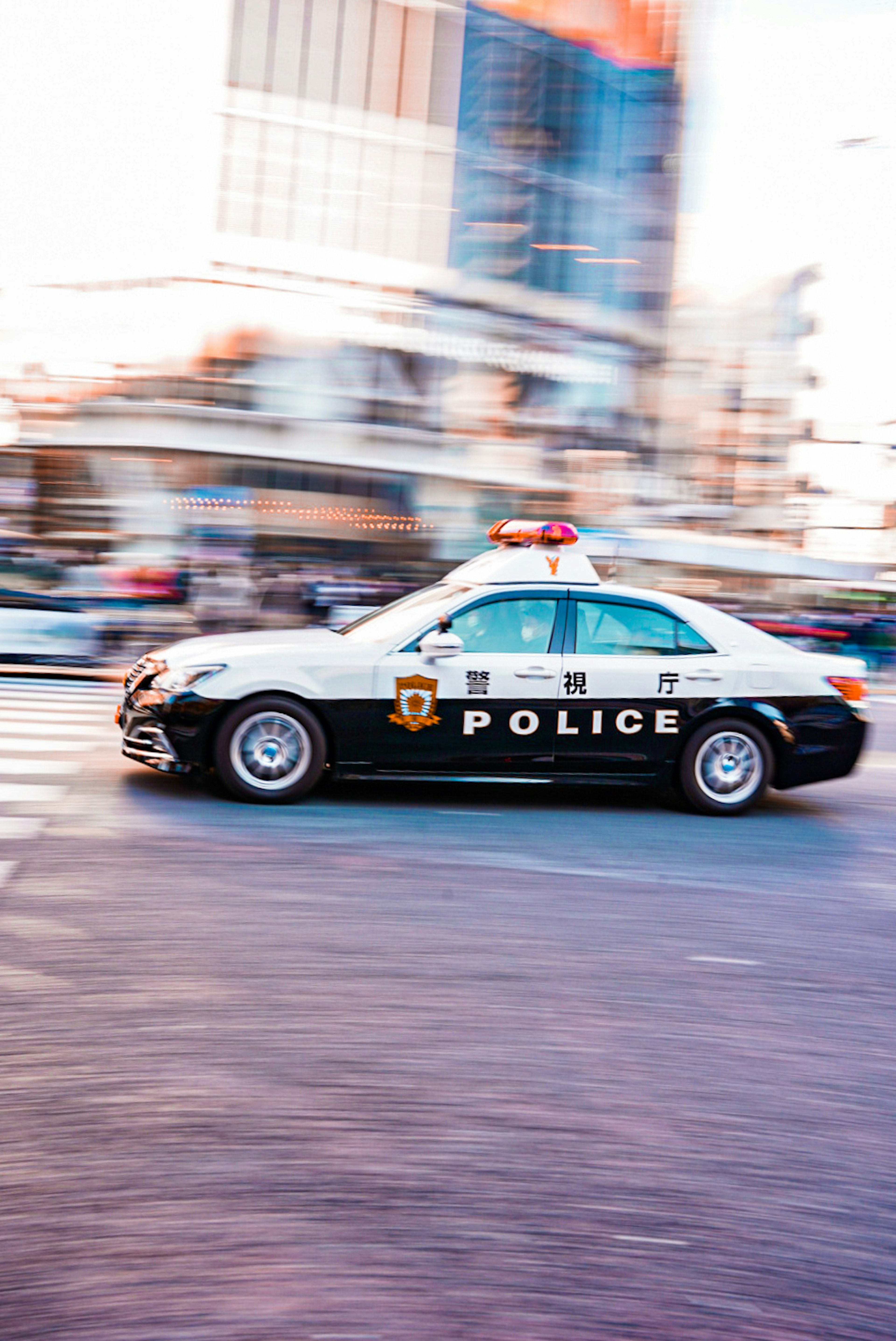 A police car driving through the city in motion