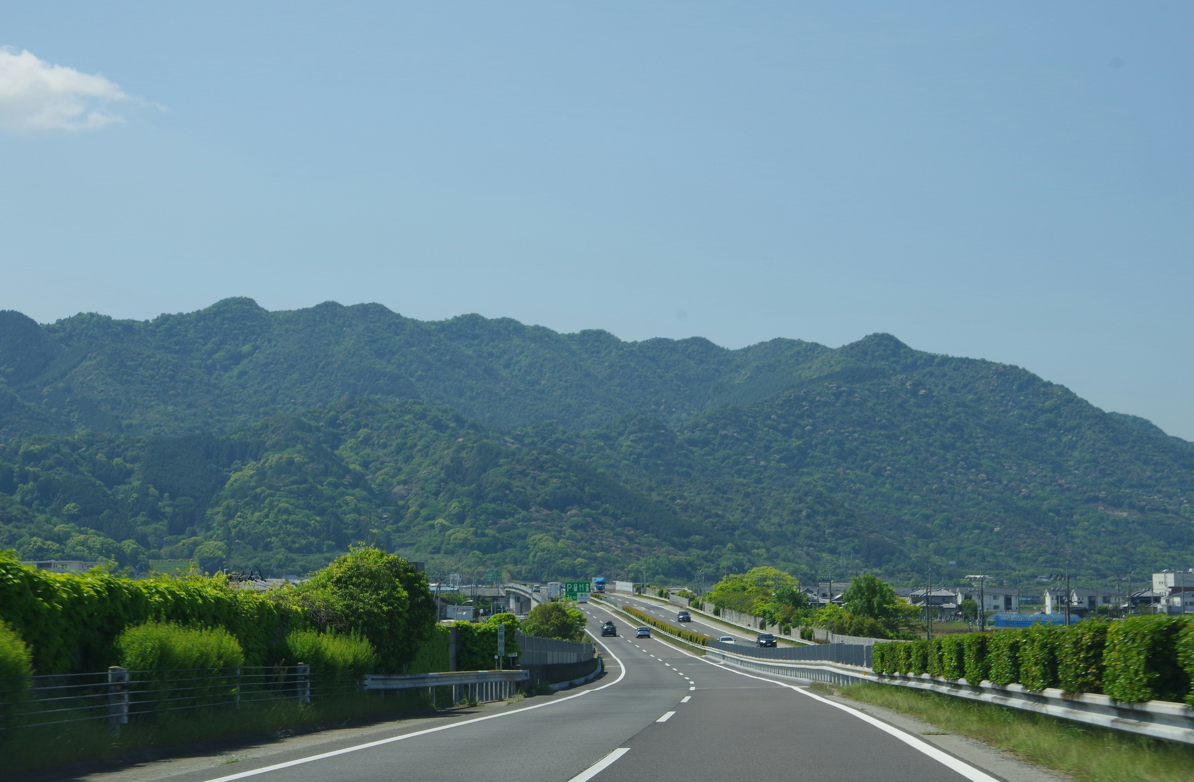 公路風景，背景是郁郁蔥蔥的山脈