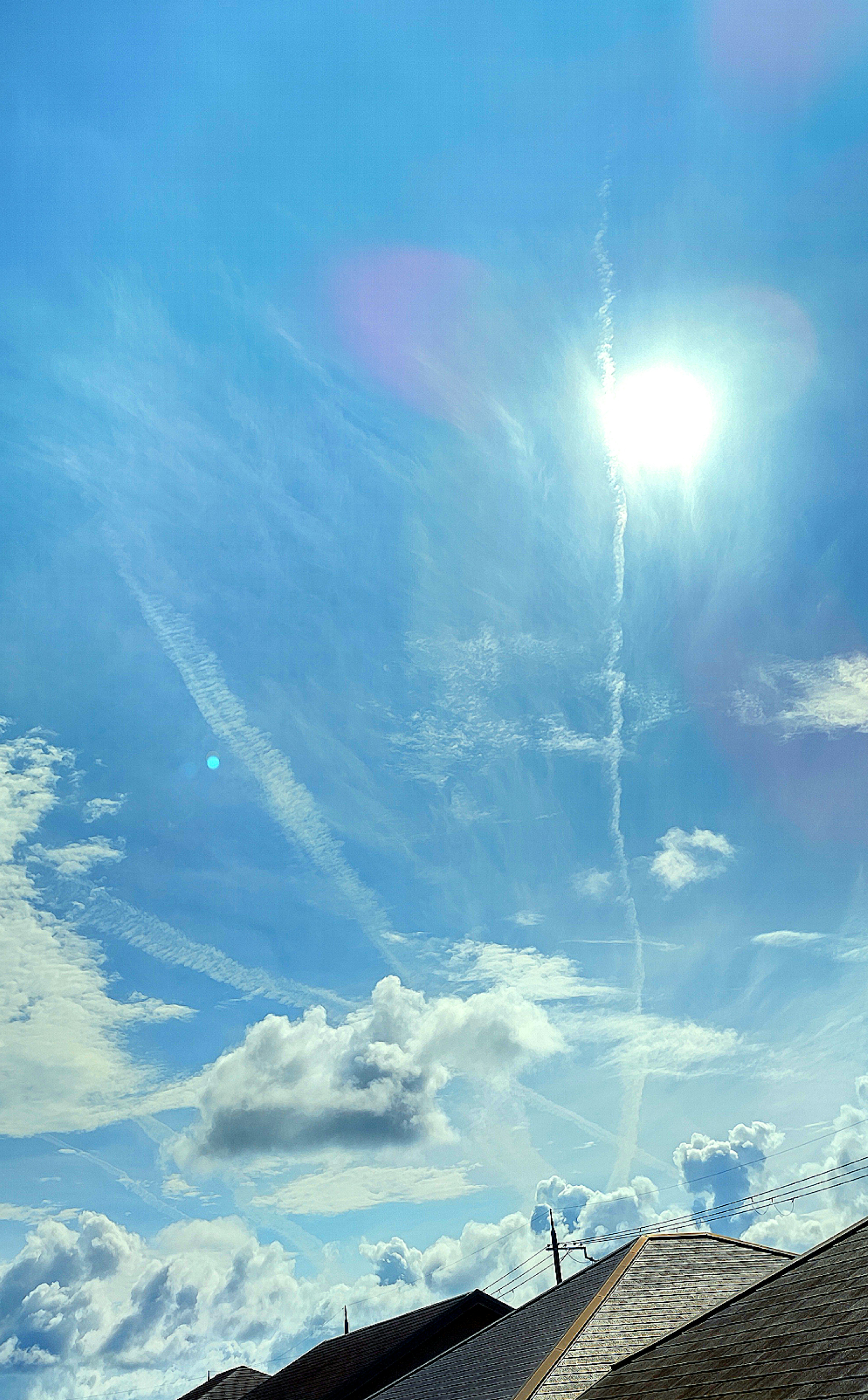 Cielo azul brillante con el sol y nubes dispersas