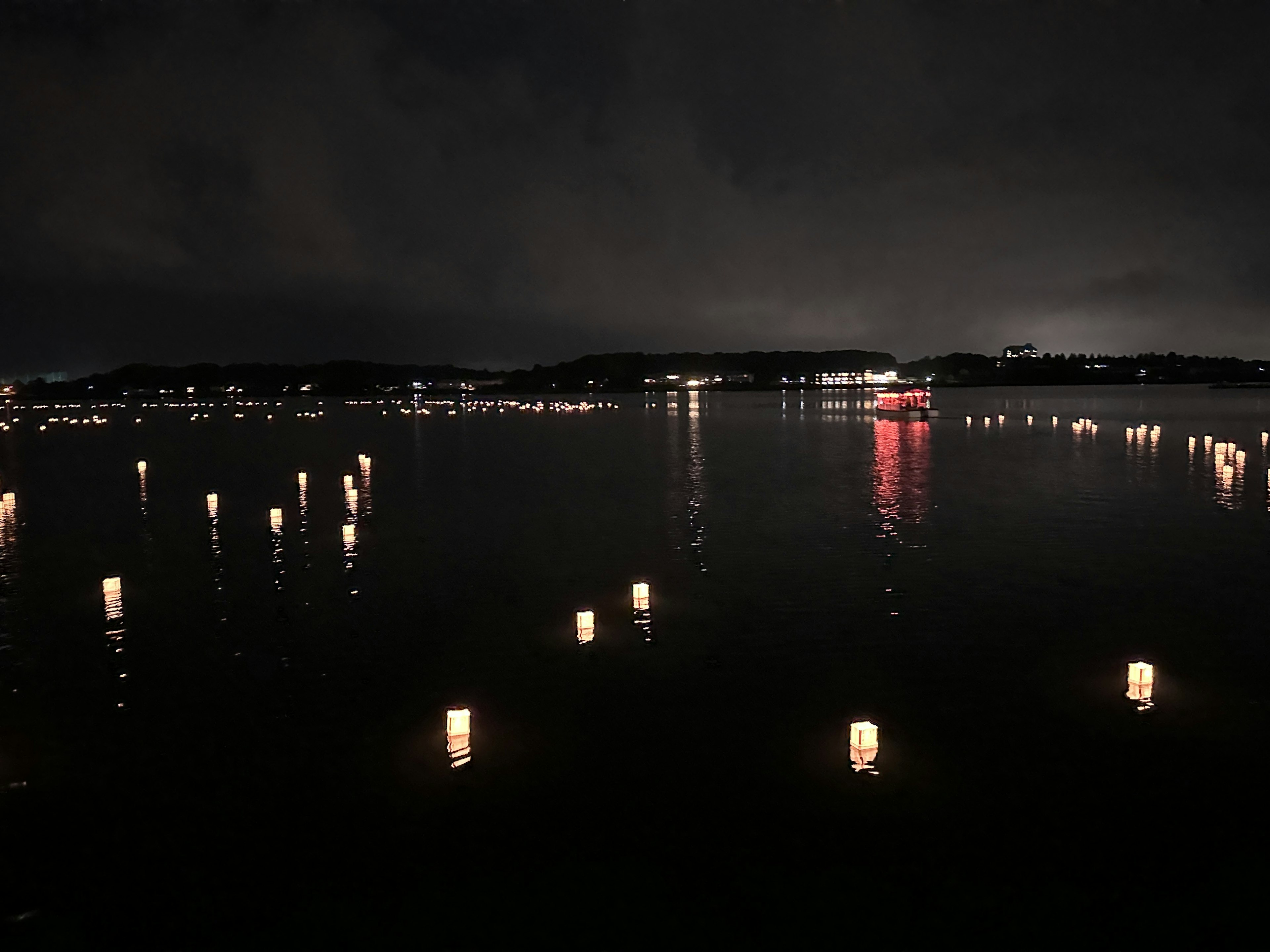 Serene night scene of lanterns floating on a lake reflecting light