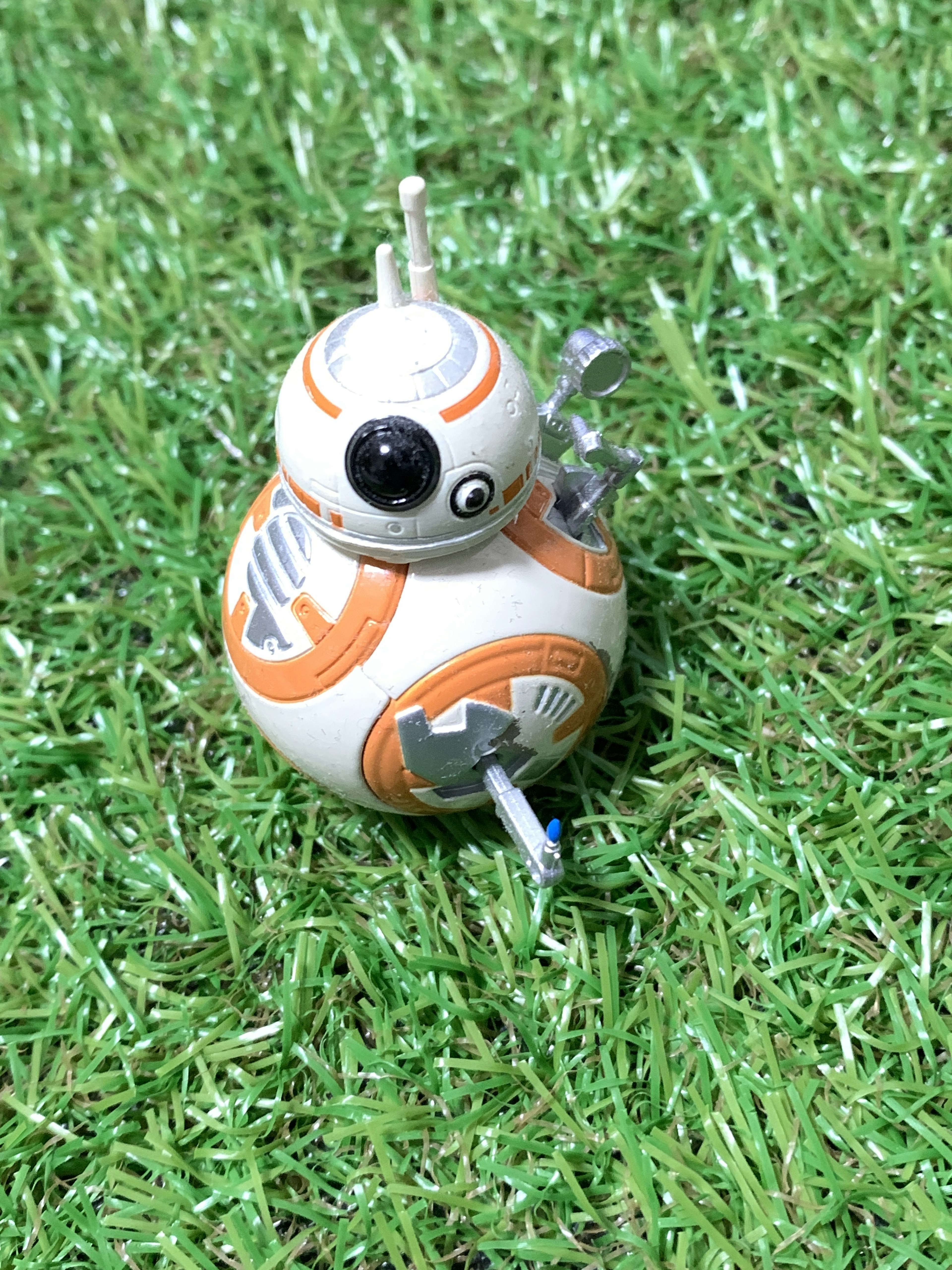 Robot BB-8 colocado sobre césped artificial verde