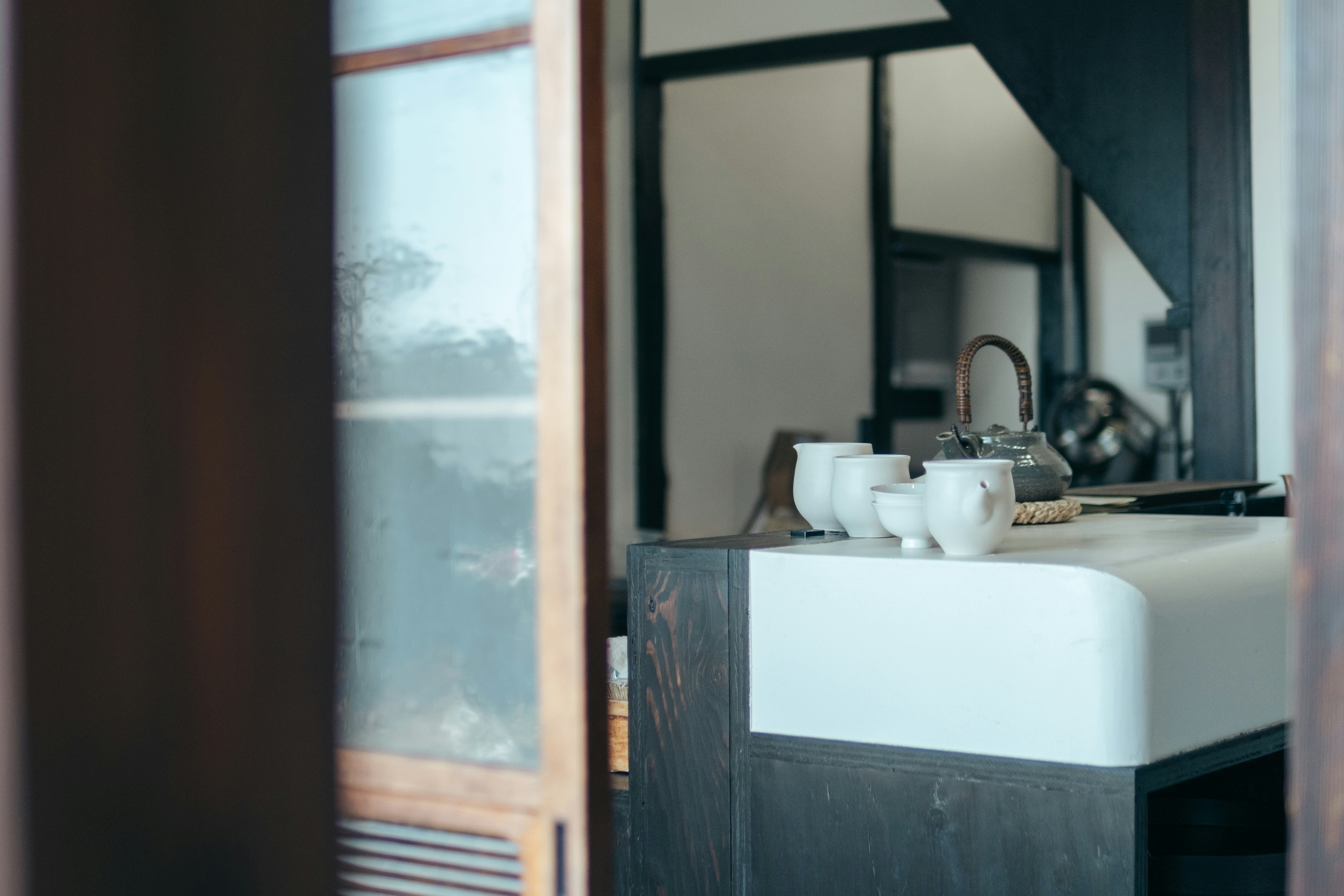 A serene kitchen space featuring white dishes and a teapot