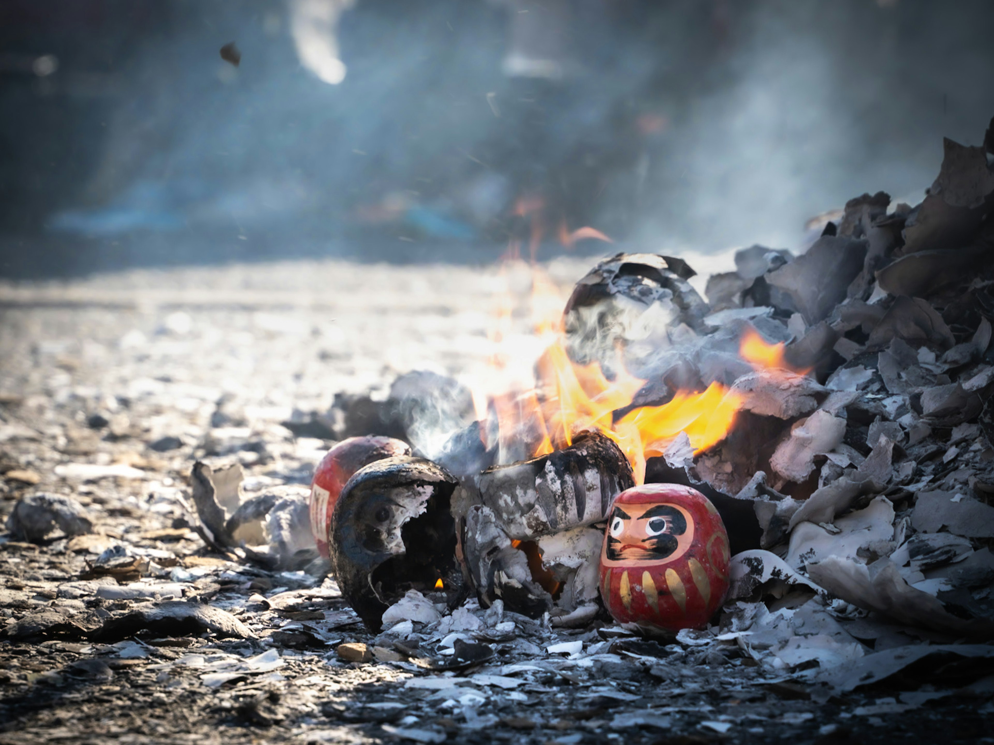 Pupazzi Daruma in fiamme e cenere