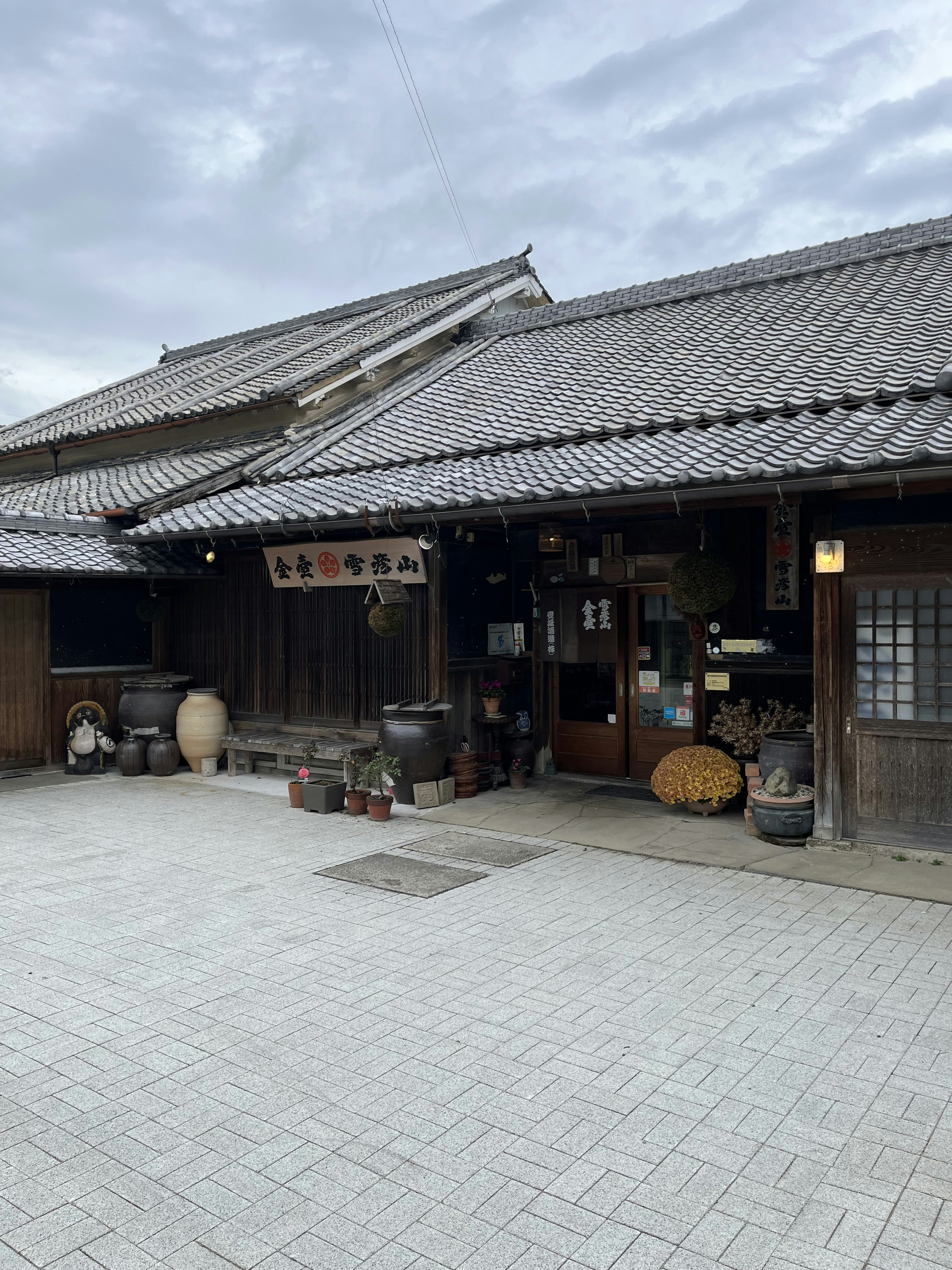 古い日本の家屋の外観と庭が見える