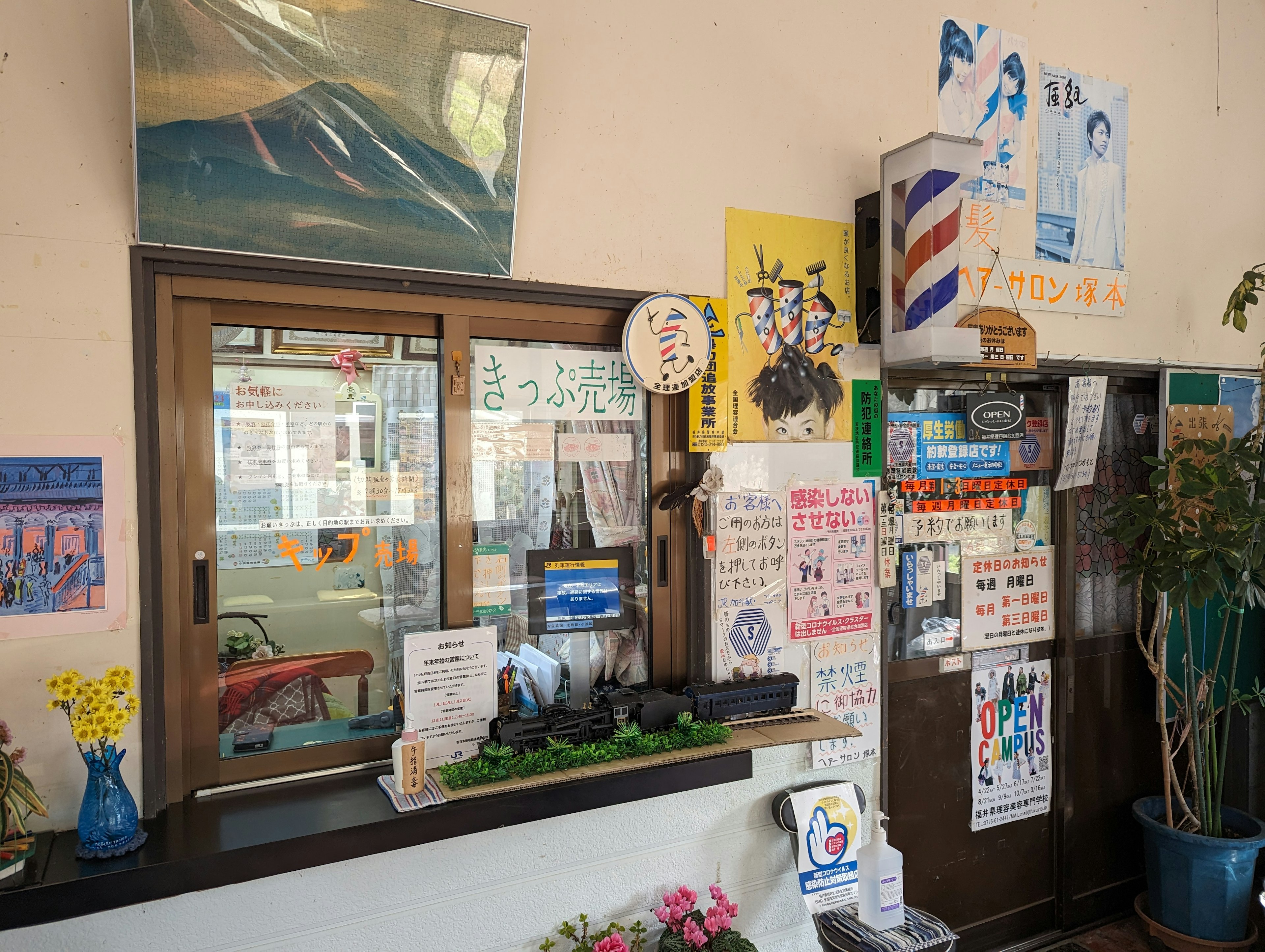 Brightly colored wall area with a service window surrounded by posters and notes