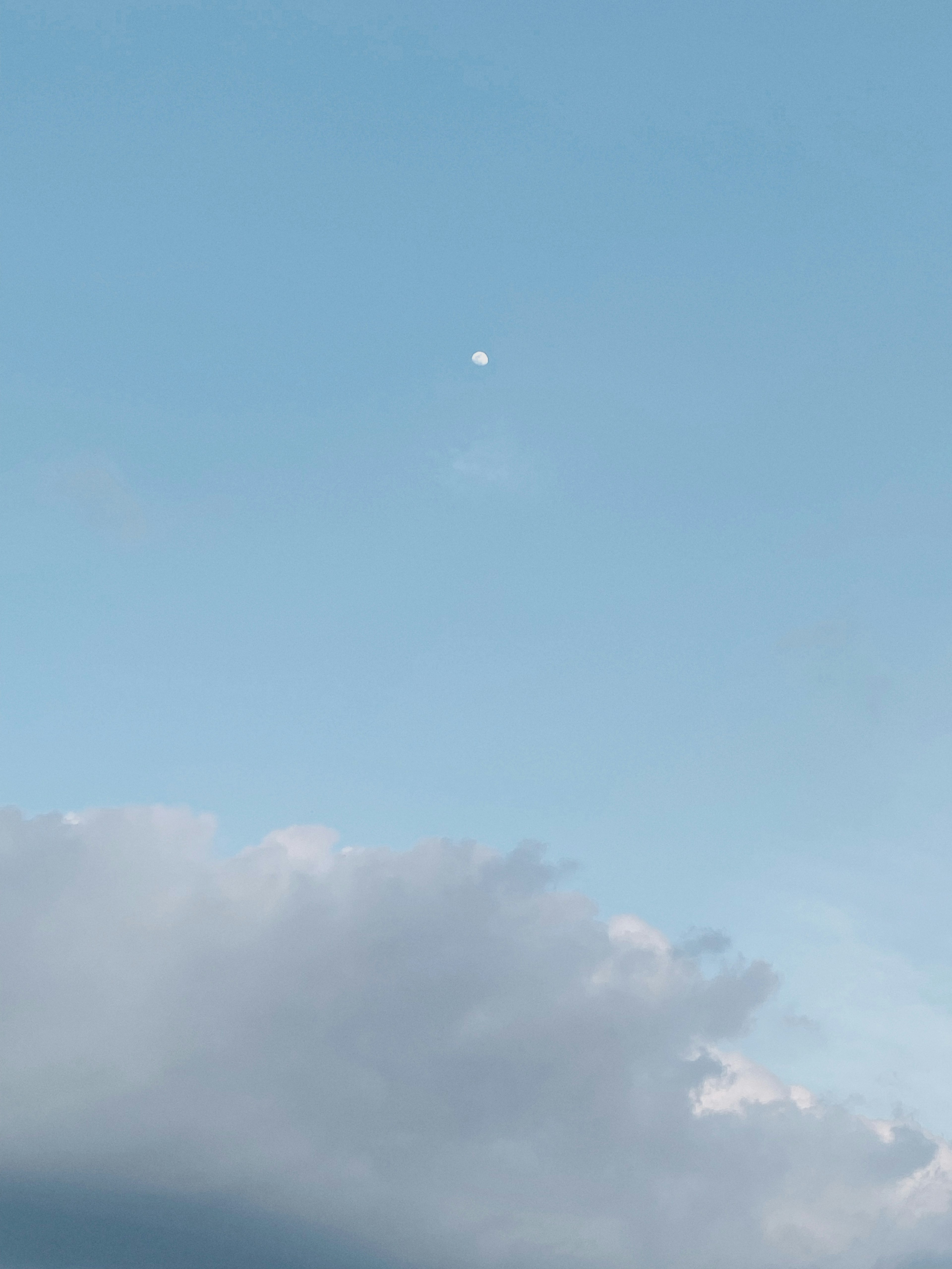 Un petit objet lumineux dans un ciel bleu avec des nuages