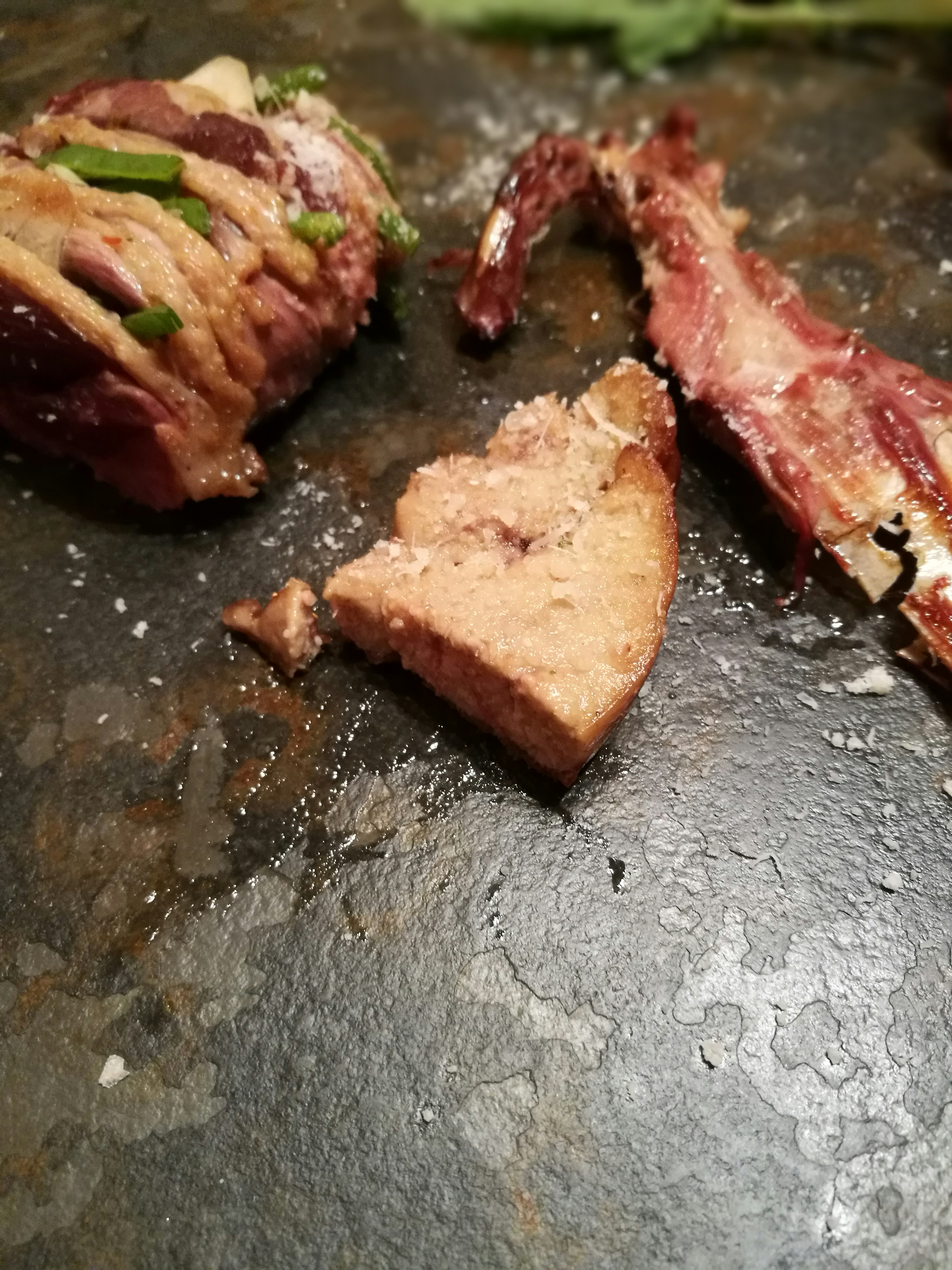 切片肉菜肴的特写，盐和香草可见