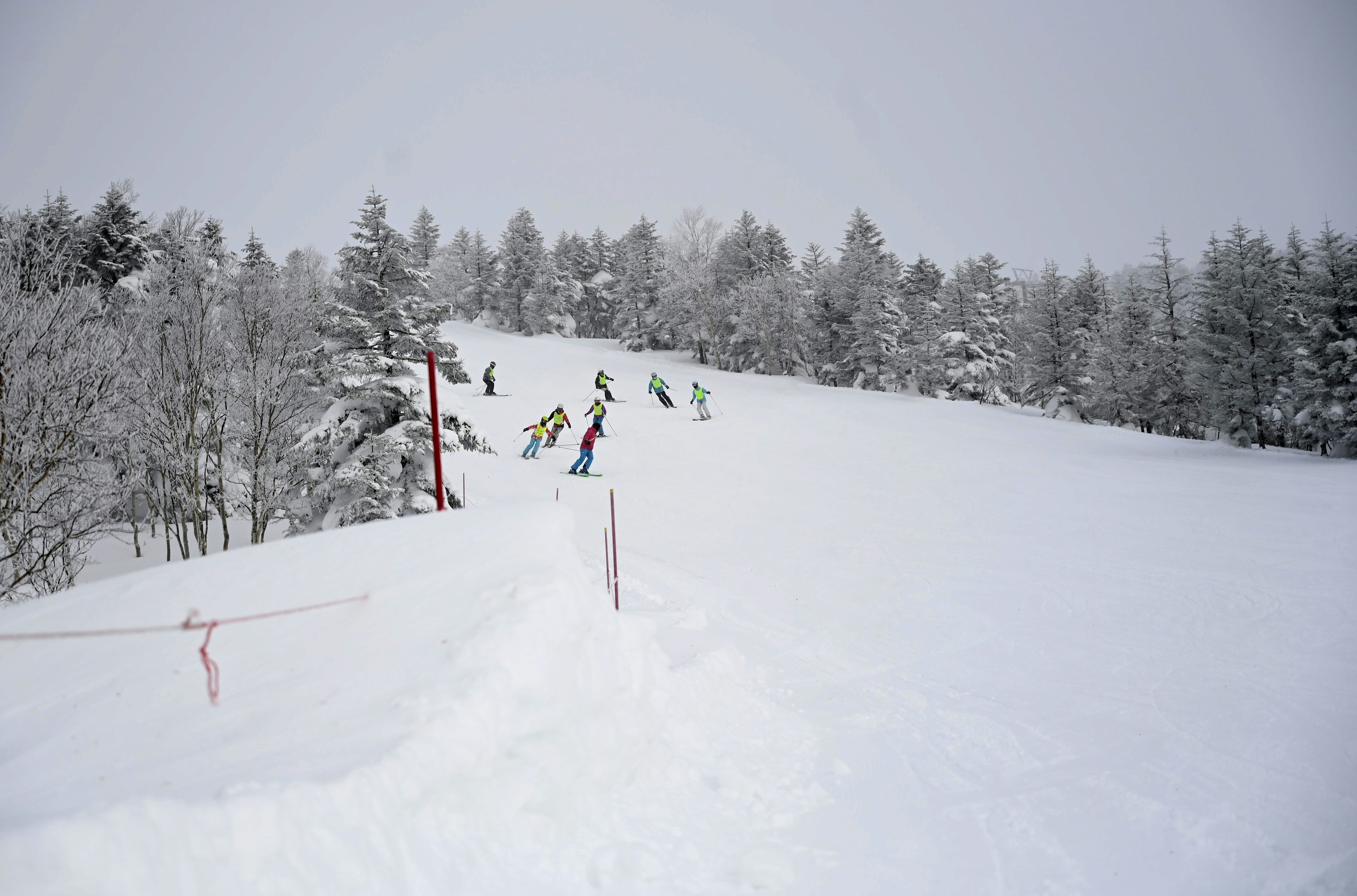 Skiers naviguant sur une pente enneigée dans une station de sports d'hiver