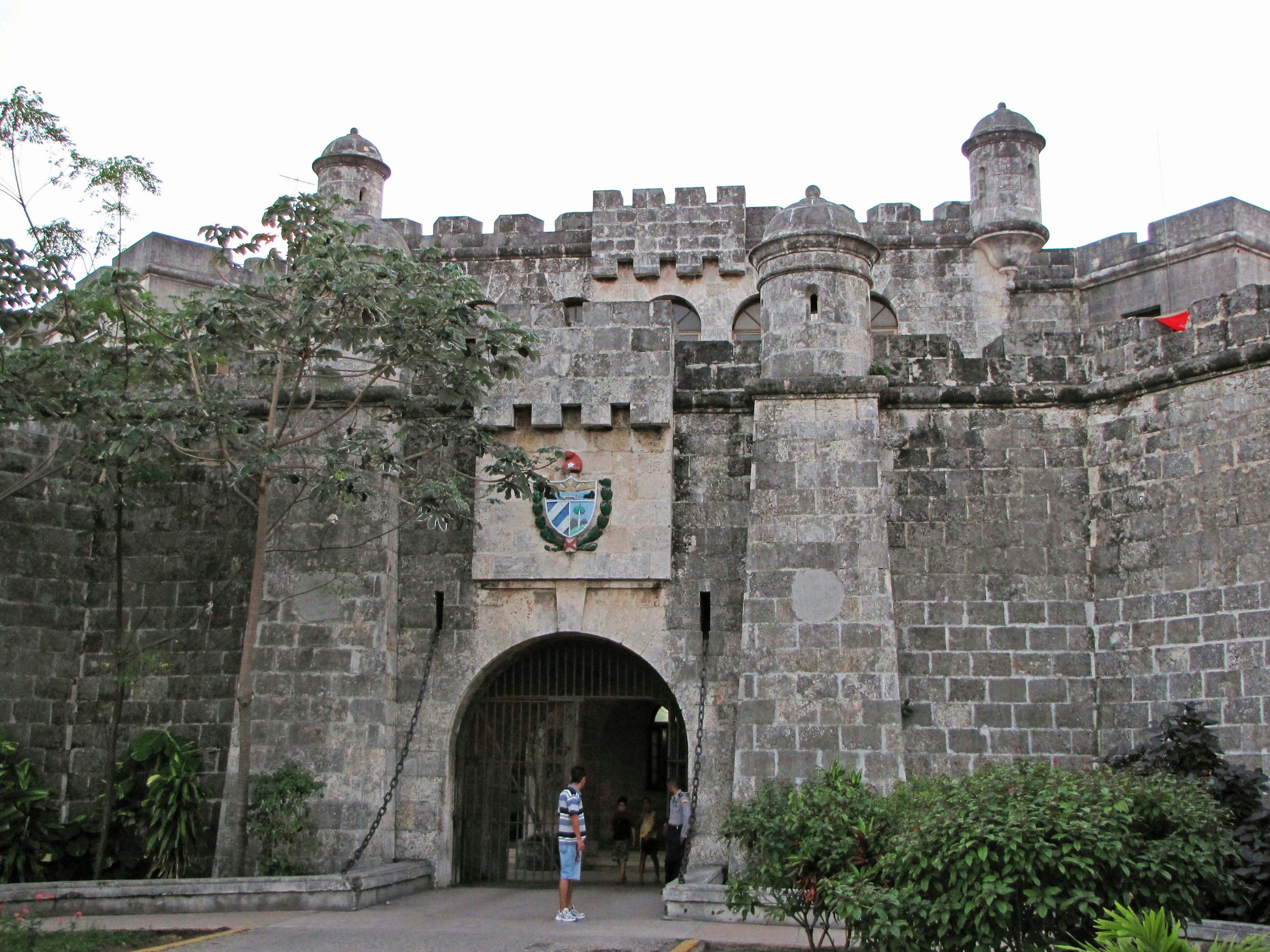 Entrance of a stone castle with a person standing in front