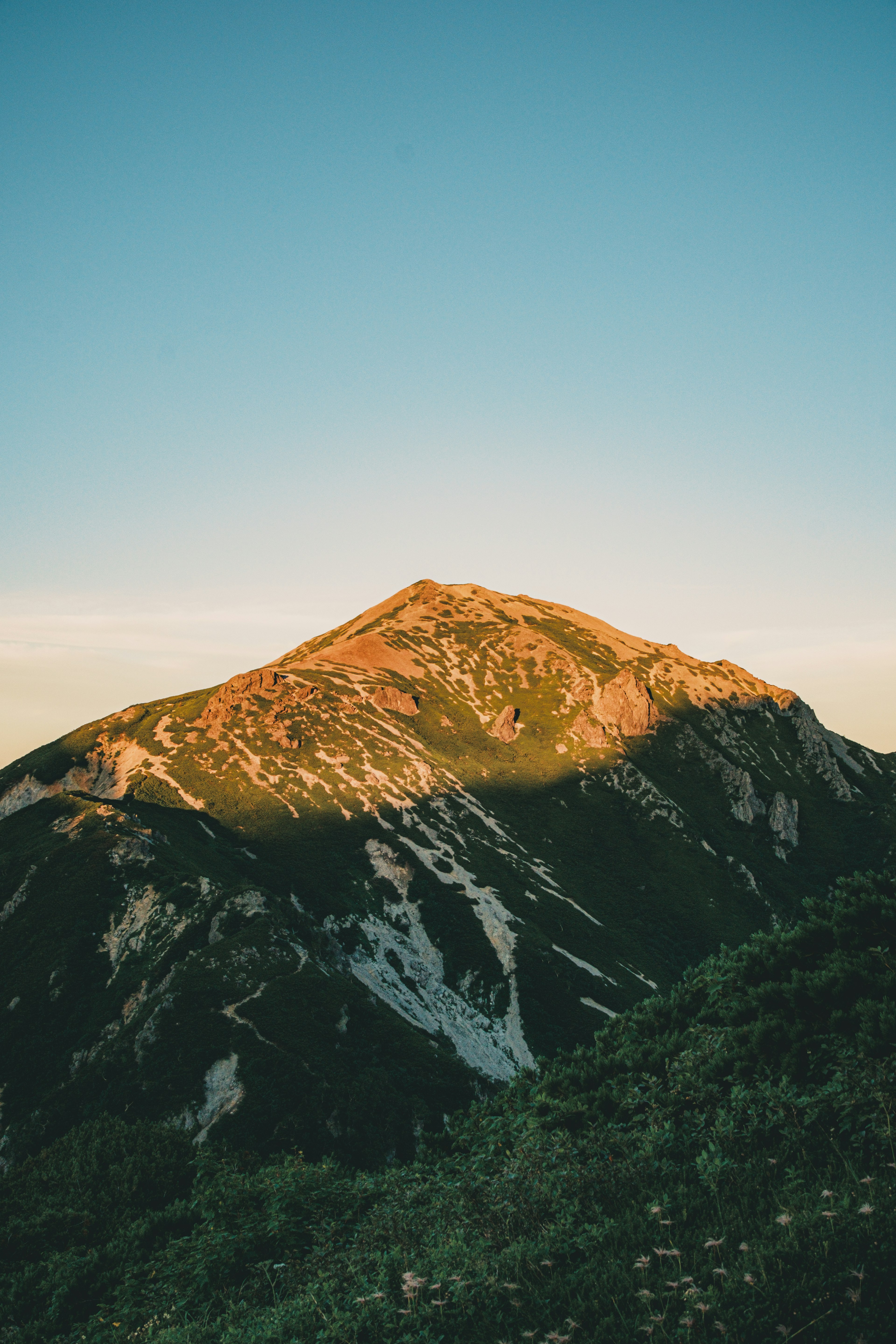 Sommet de montagne illuminé par la lumière du coucher de soleil