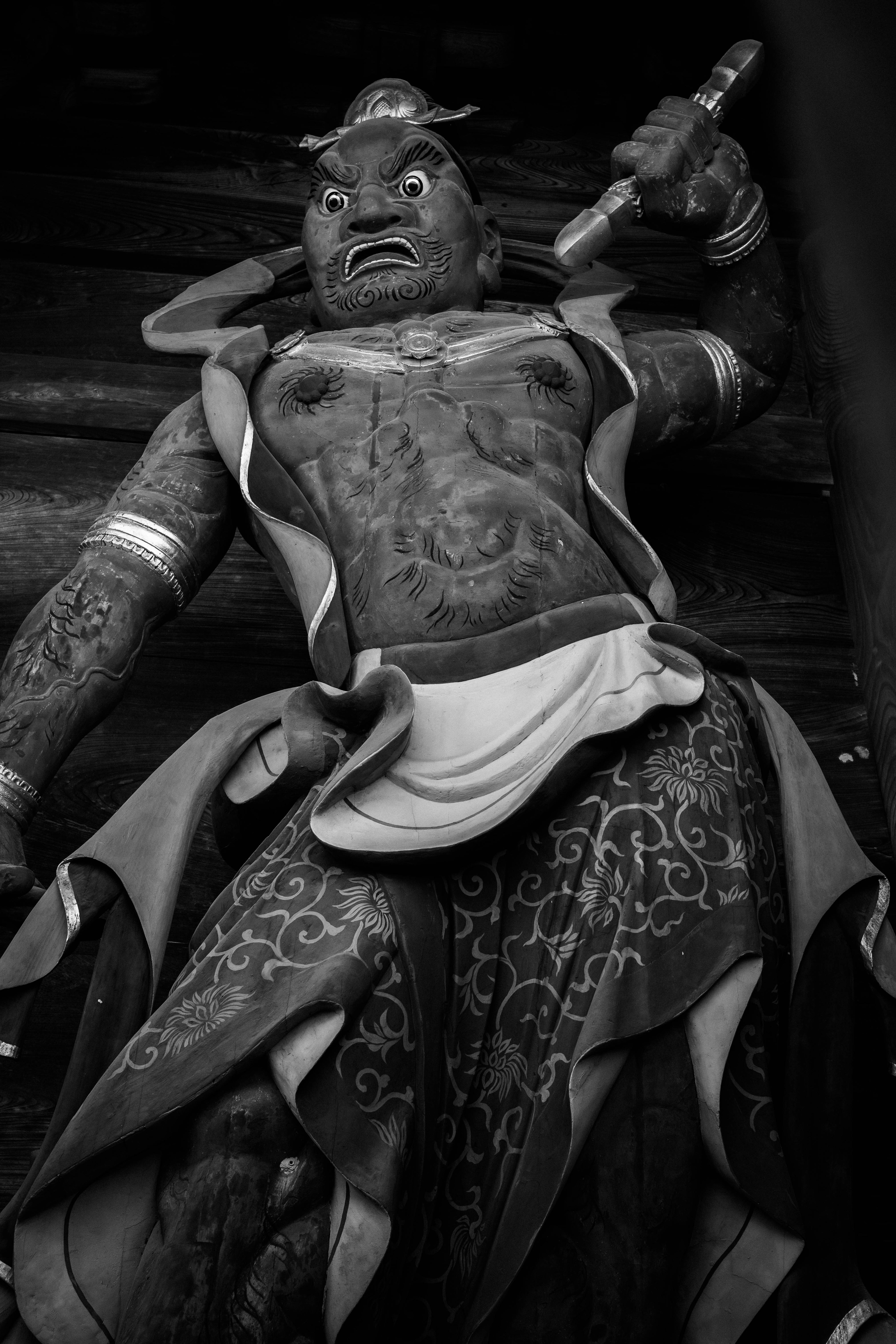 Black and white carved statue with an angry expression