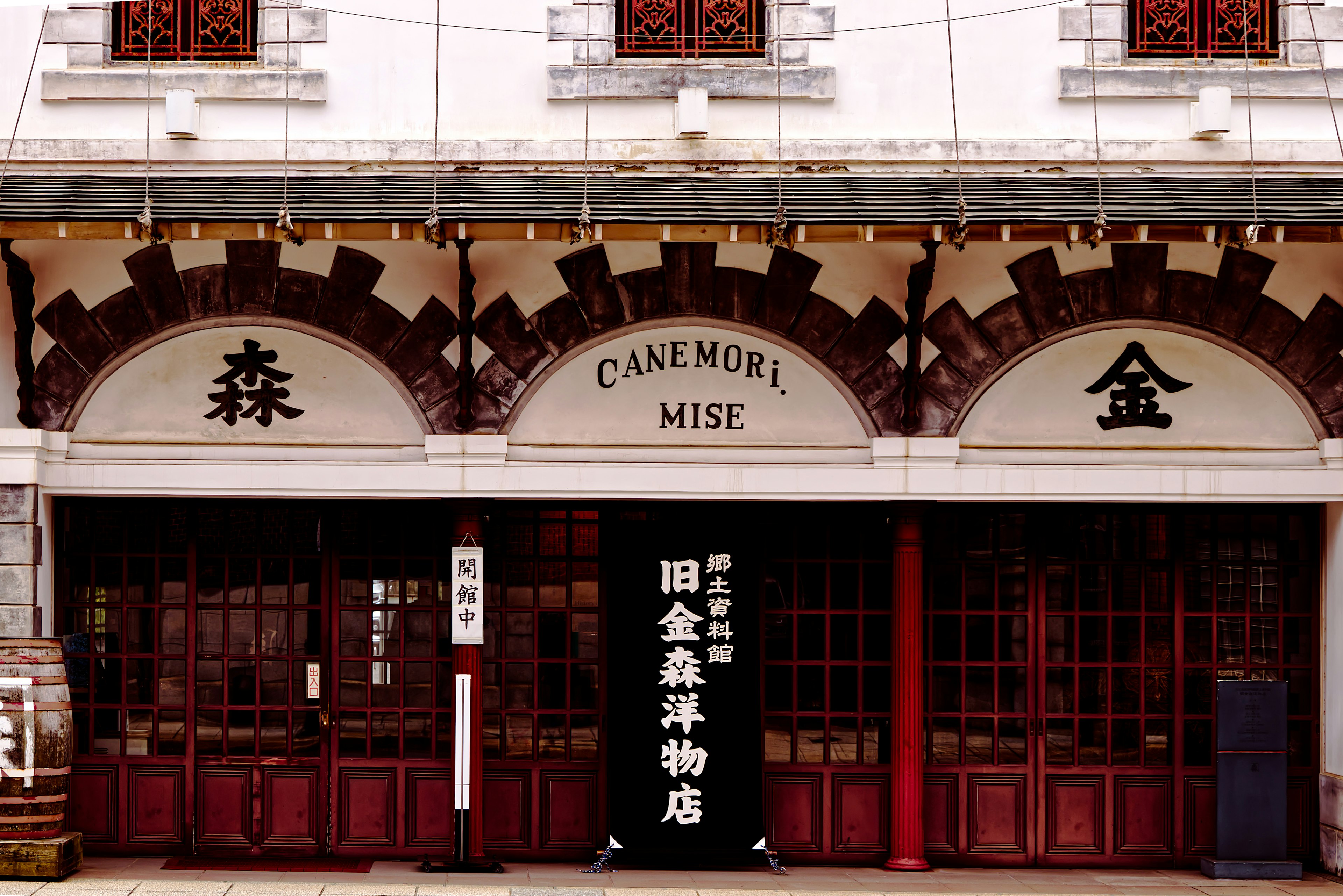 Facade of an old building featuring Chinese characters and distinctive red wooden doors